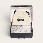 Zapatilla OLKI Calán verde musgo de cuero vacuno con cordones de algodón y planta de caucho antideslizante, presentada en su caja con bolsa protectora. Estilo artesanal.