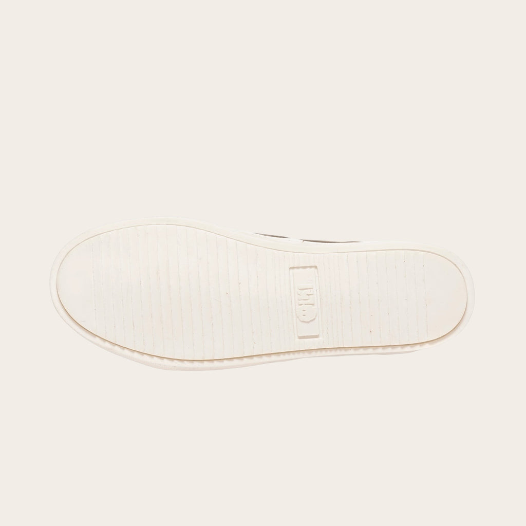 Zapatilla OLKI La Campana de cuero camel con planta blanca y cordones de algodón encerado.