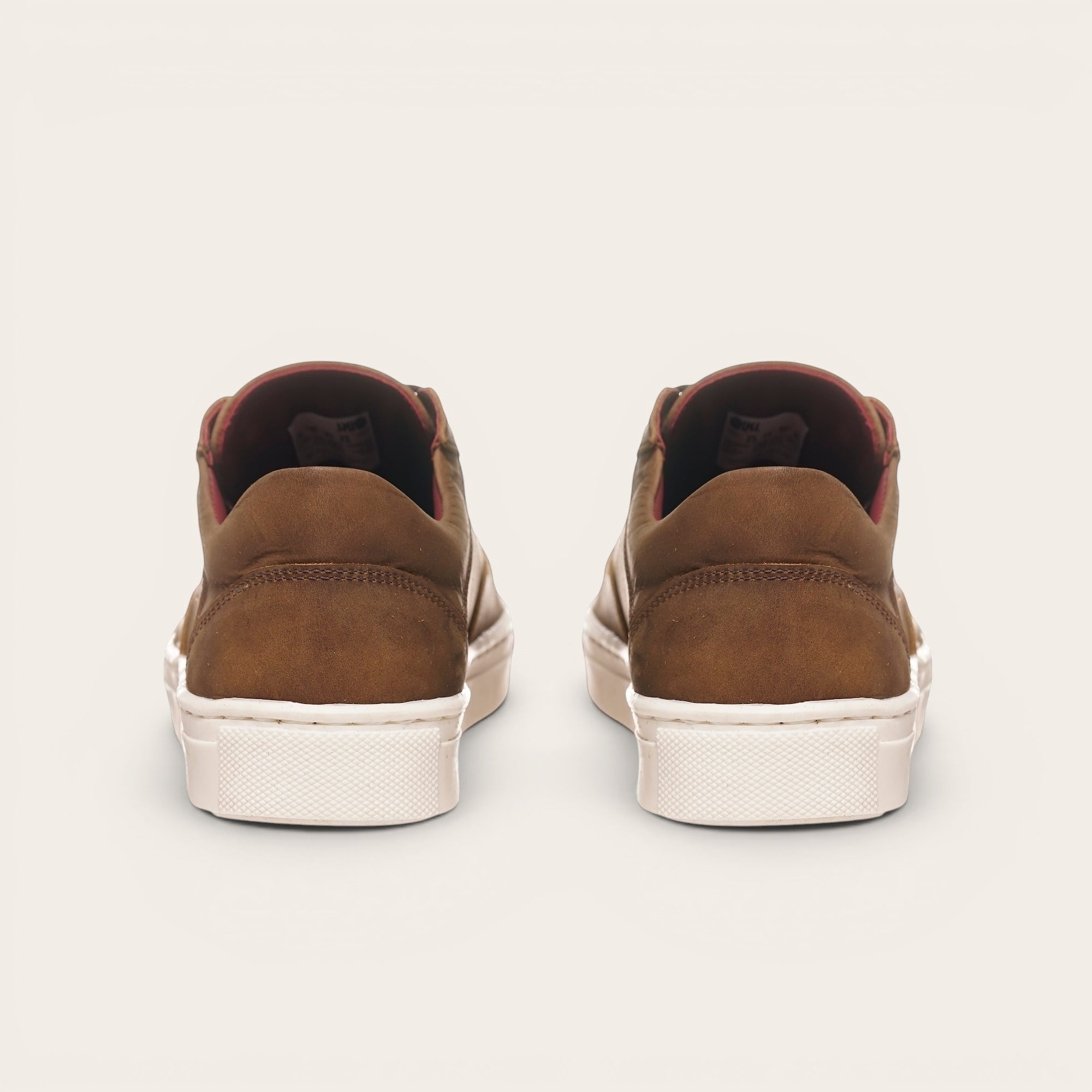 Zapatillas OLKI La Campana de cuero camel con planta blanca y forro burdeos. Diseño minimalista y urbano.