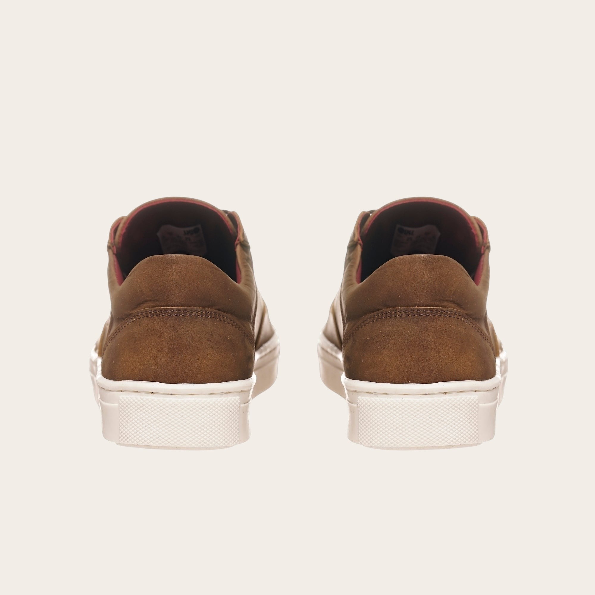 Zapatillas OLKI La Campana de cuero camel con planta blanca y forro burdeos. Diseño minimalista y urbano.