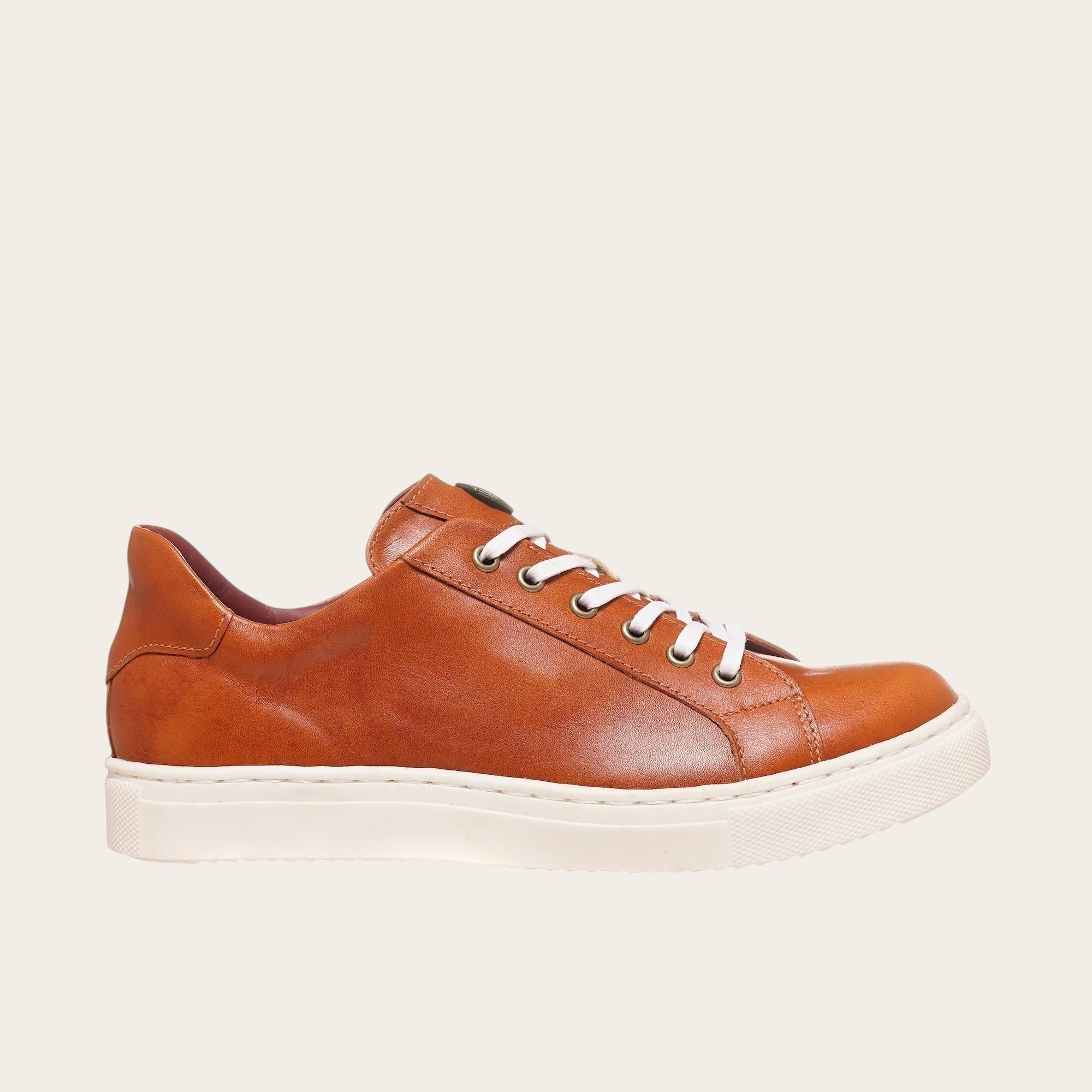 Zapatilla OLKI Tronador de cuero vacuno tostado con cordones blancos y planta de caucho blanca. Diseño artesanal chileno.