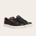 Zapatilla OLKI La Campana negra de cuero con detalles burdeos y planta blanca. Diseño urbano minimalista.
