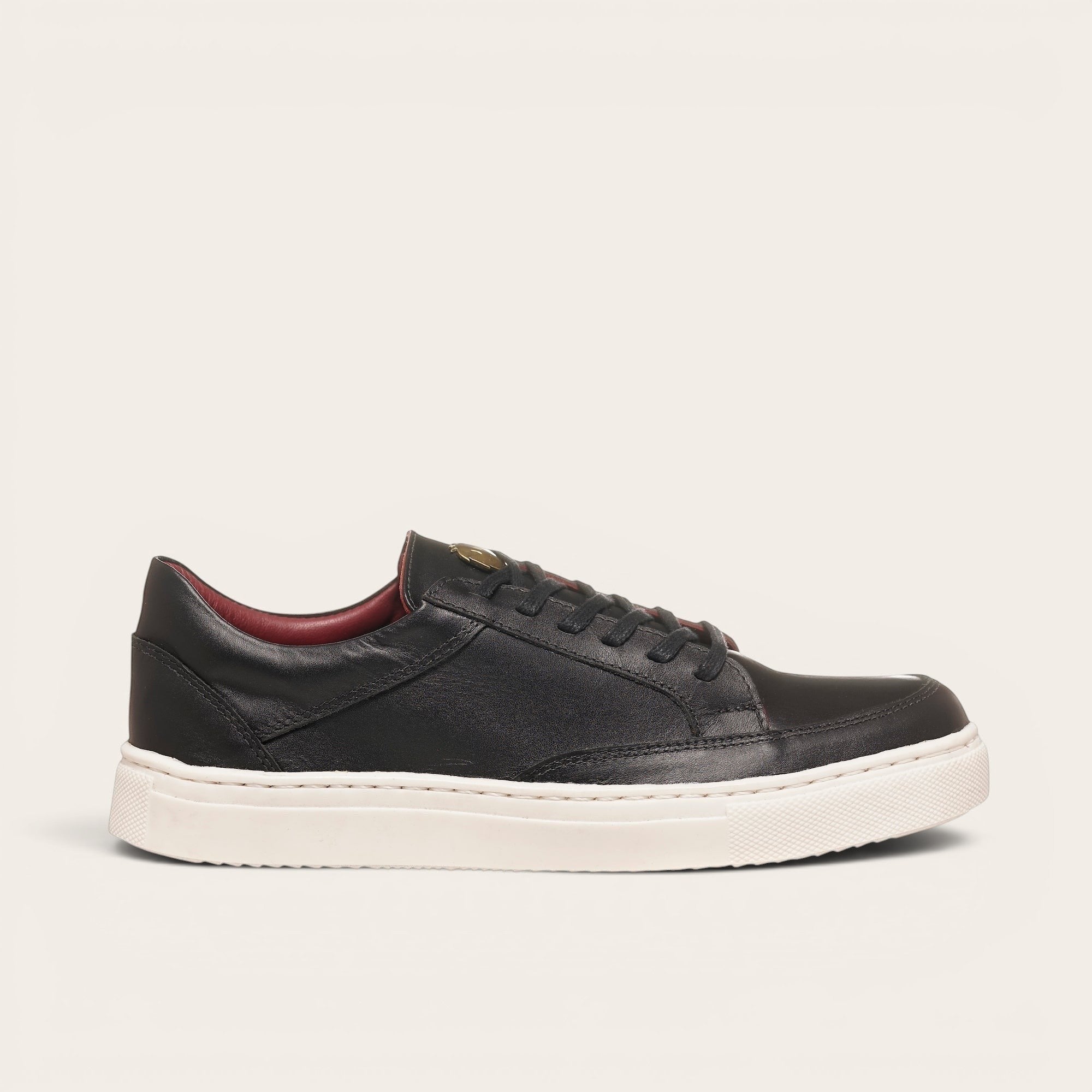 Zapatilla OLKI La Campana negra de cuero con planta blanca y forro burdeos. Diseño minimalista y urbano.