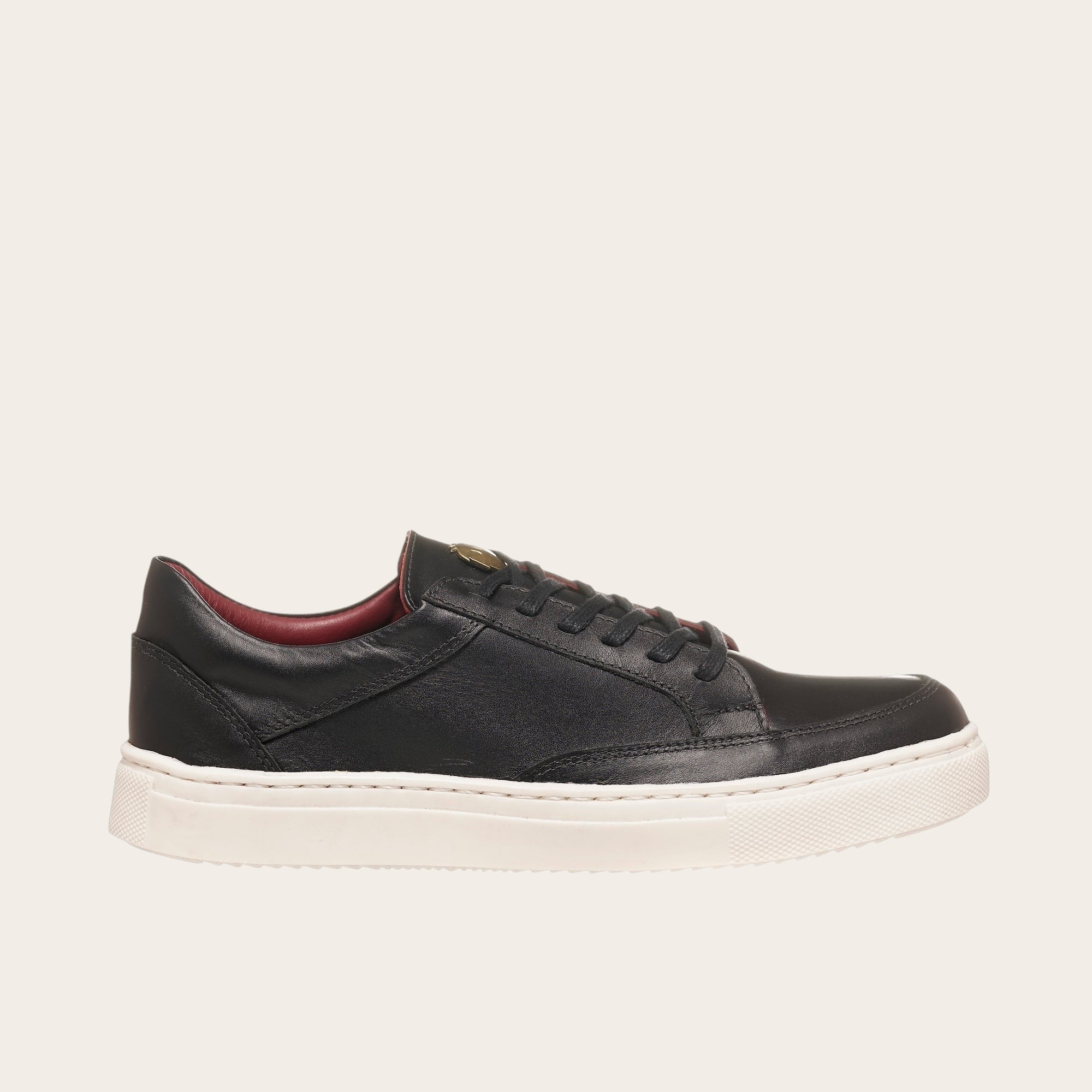 Zapatilla OLKI La Campana negra de cuero con planta blanca y forro burdeos. Diseño minimalista y urbano.