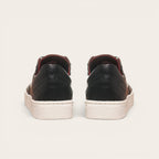 Zapatilla OLKI La Campana negra de cuero con planta blanca y forro burdeos. Diseño urbano minimalista.