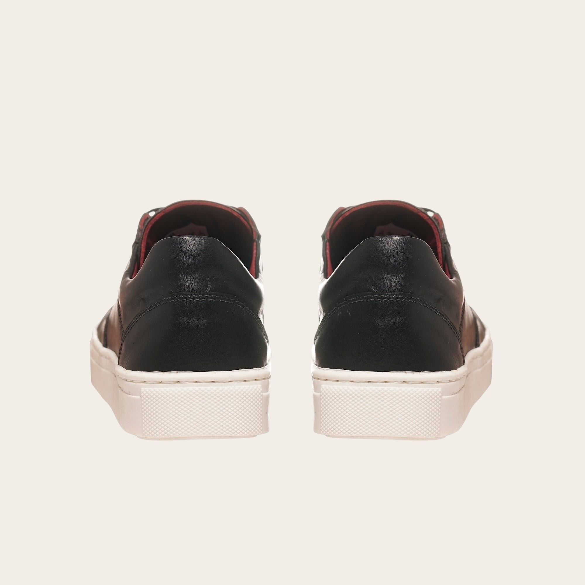 Zapatilla OLKI La Campana negra de cuero con planta blanca y forro burdeos. Diseño urbano minimalista.
