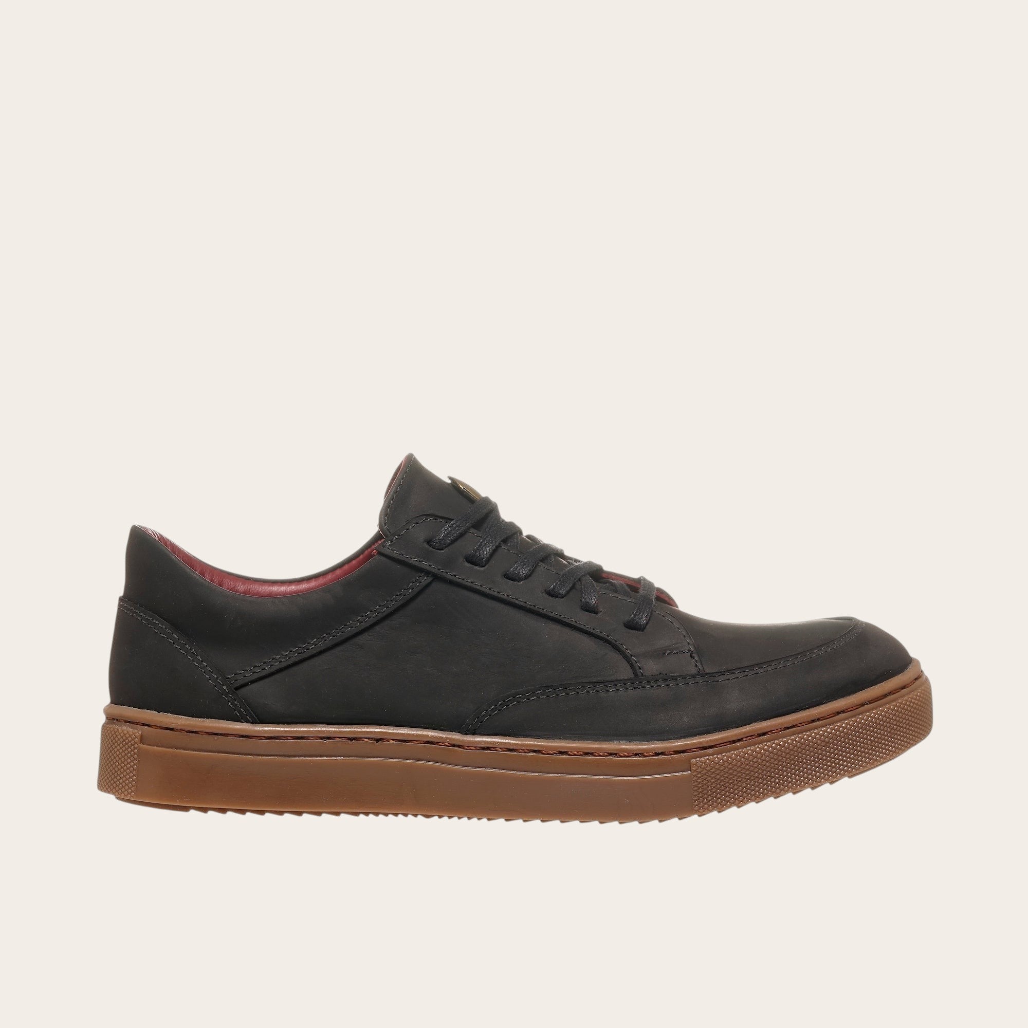 Zapatilla OLKI La Campana negra de cuero con planta de caucho cristal y forro burdeos. Diseño urbano.