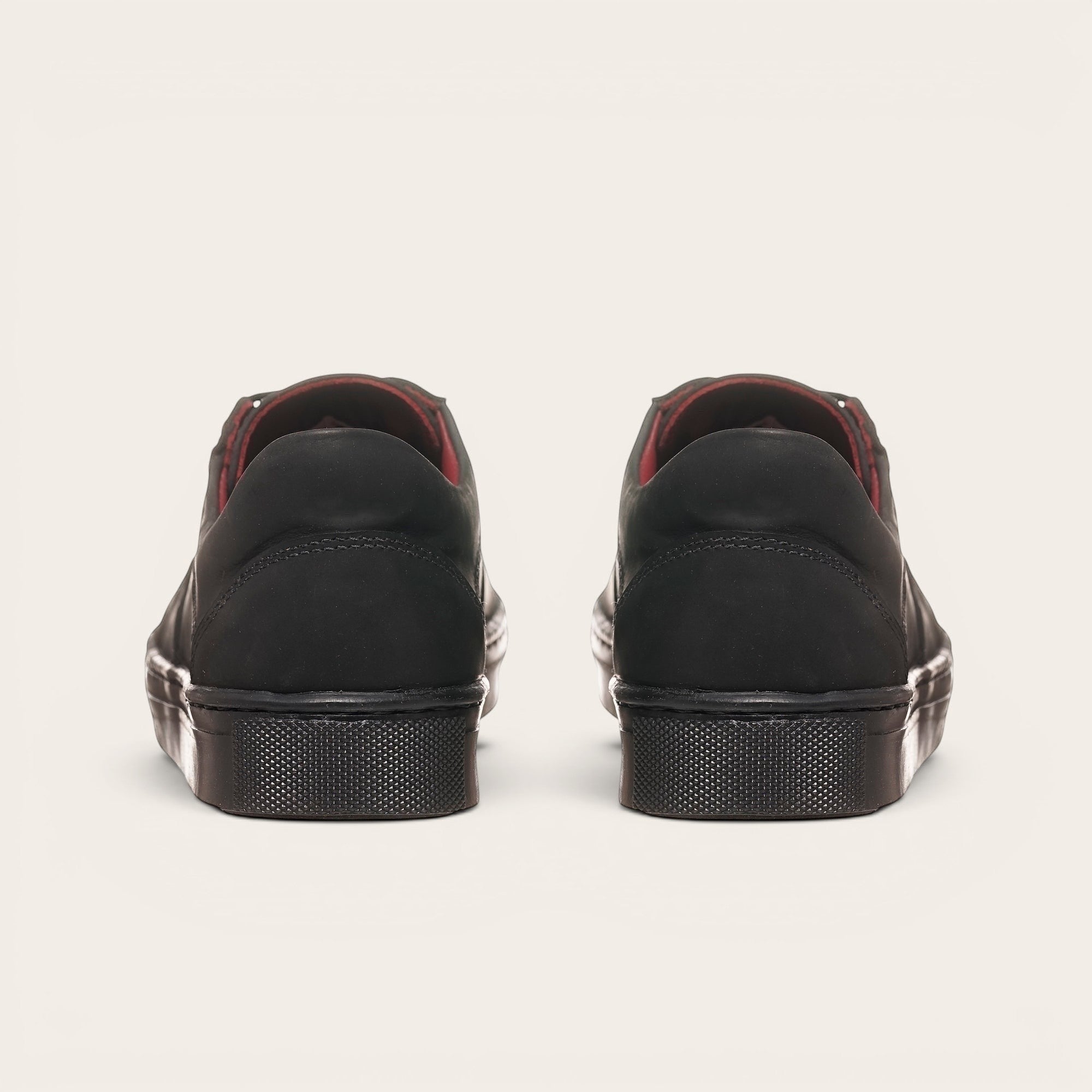 Zapatillas OLKI La Campana negras de cuero con forro burdeos y suela de caucho antideslizante.