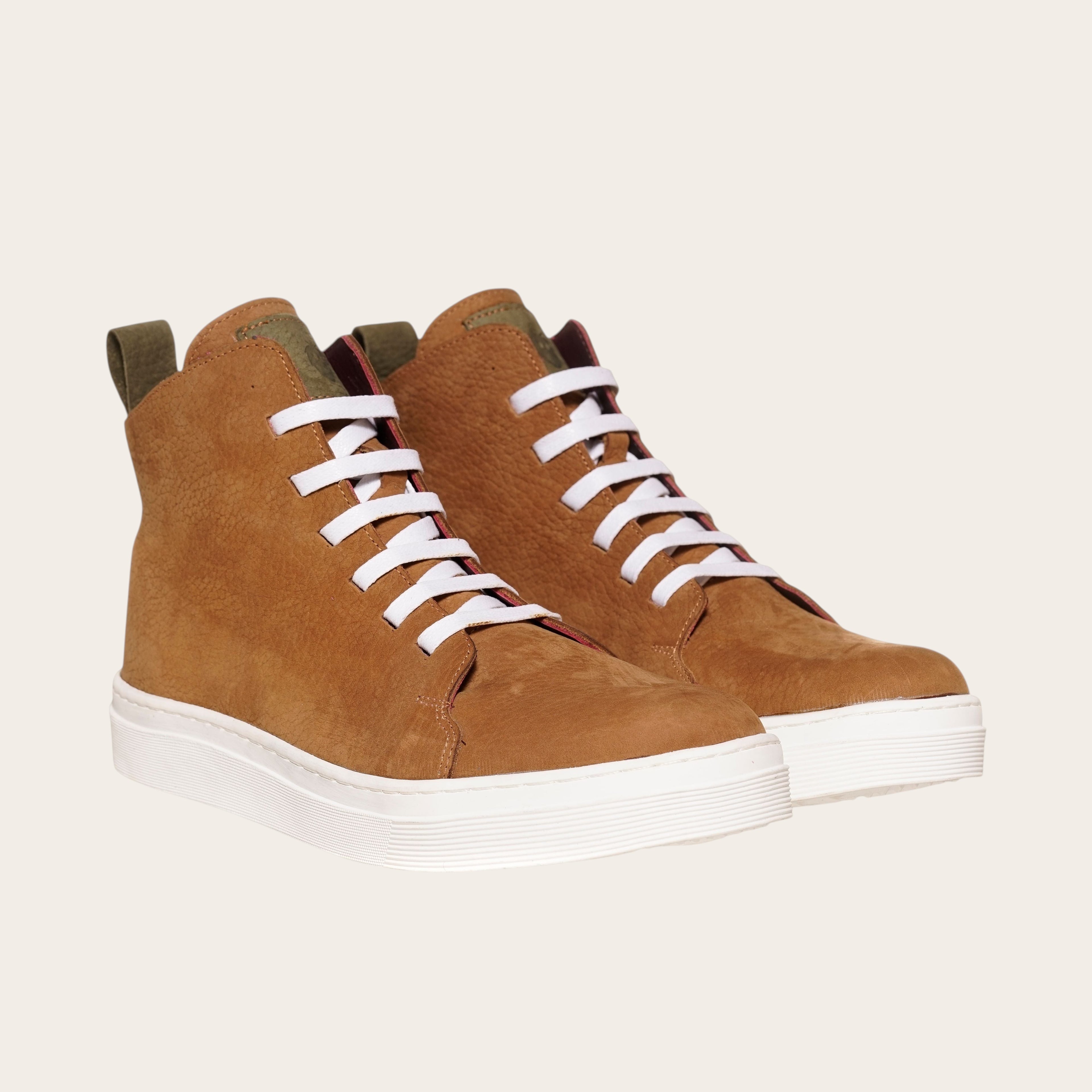 Zapatilla Manquehue de OLKI en cuero nobuk color avellana con cordones blancos y planta blanca de caucho. Diseño urbano.