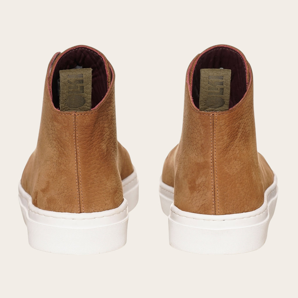 Zapatilla Manquehue de OLKI en cuero nobuk color avellana con cordones blancos y planta blanca de caucho. Diseño urbano.