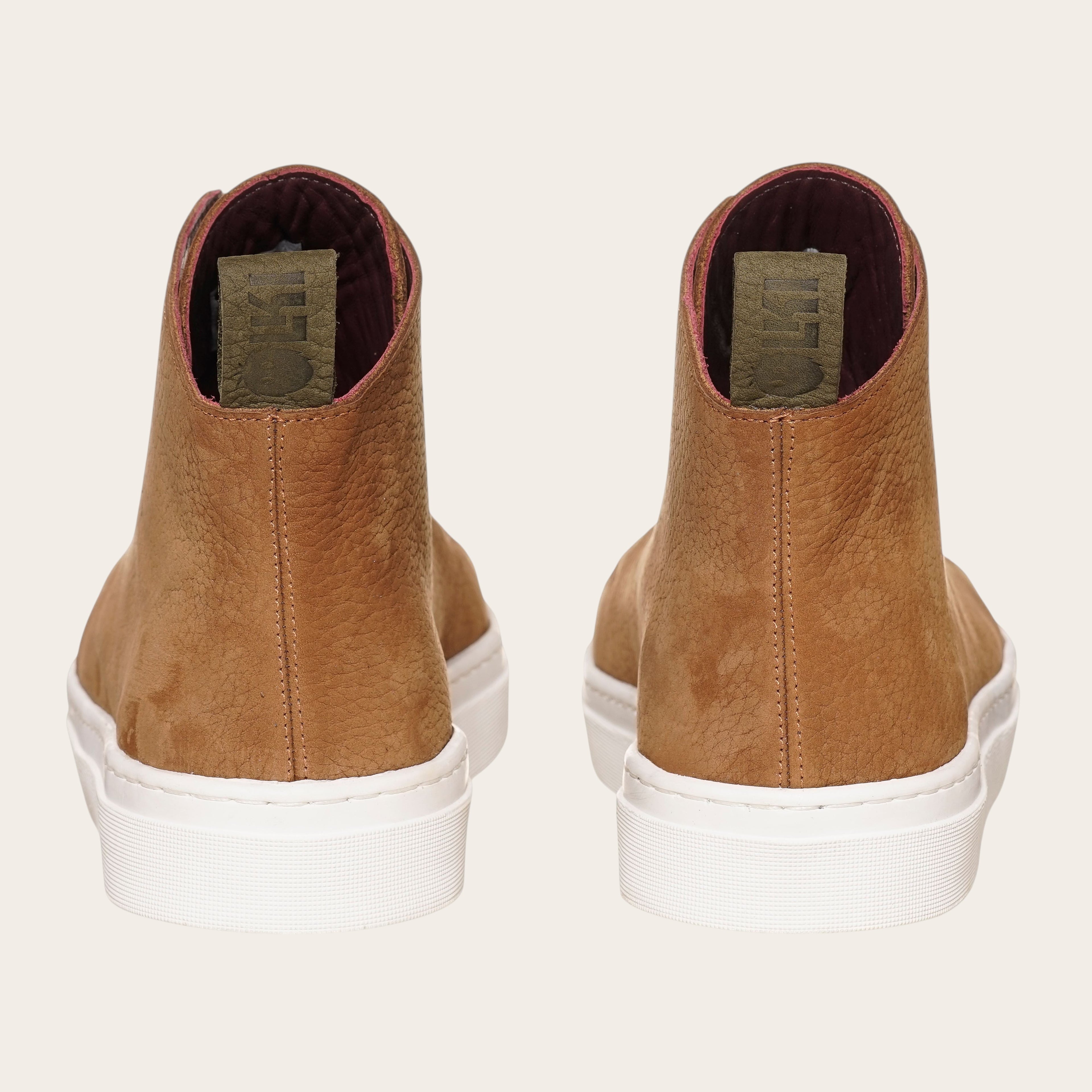 Zapatilla Manquehue de OLKI en cuero nobuk color avellana con cordones blancos y planta blanca de caucho. Diseño urbano.