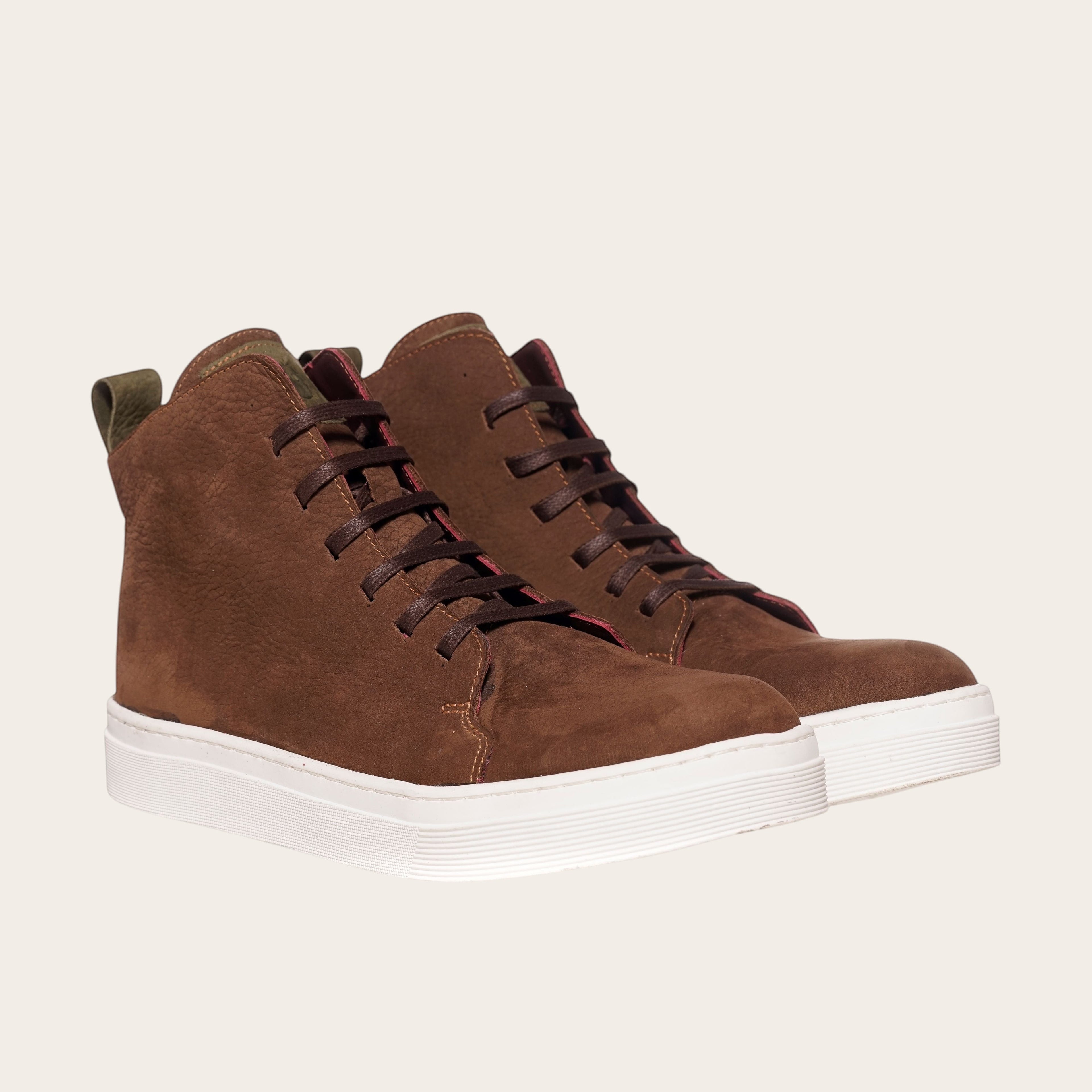 Zapatilla alta chocolate de cuero noburo con cordones de algodón encerado y planta blanca de caucho. OLKI.
