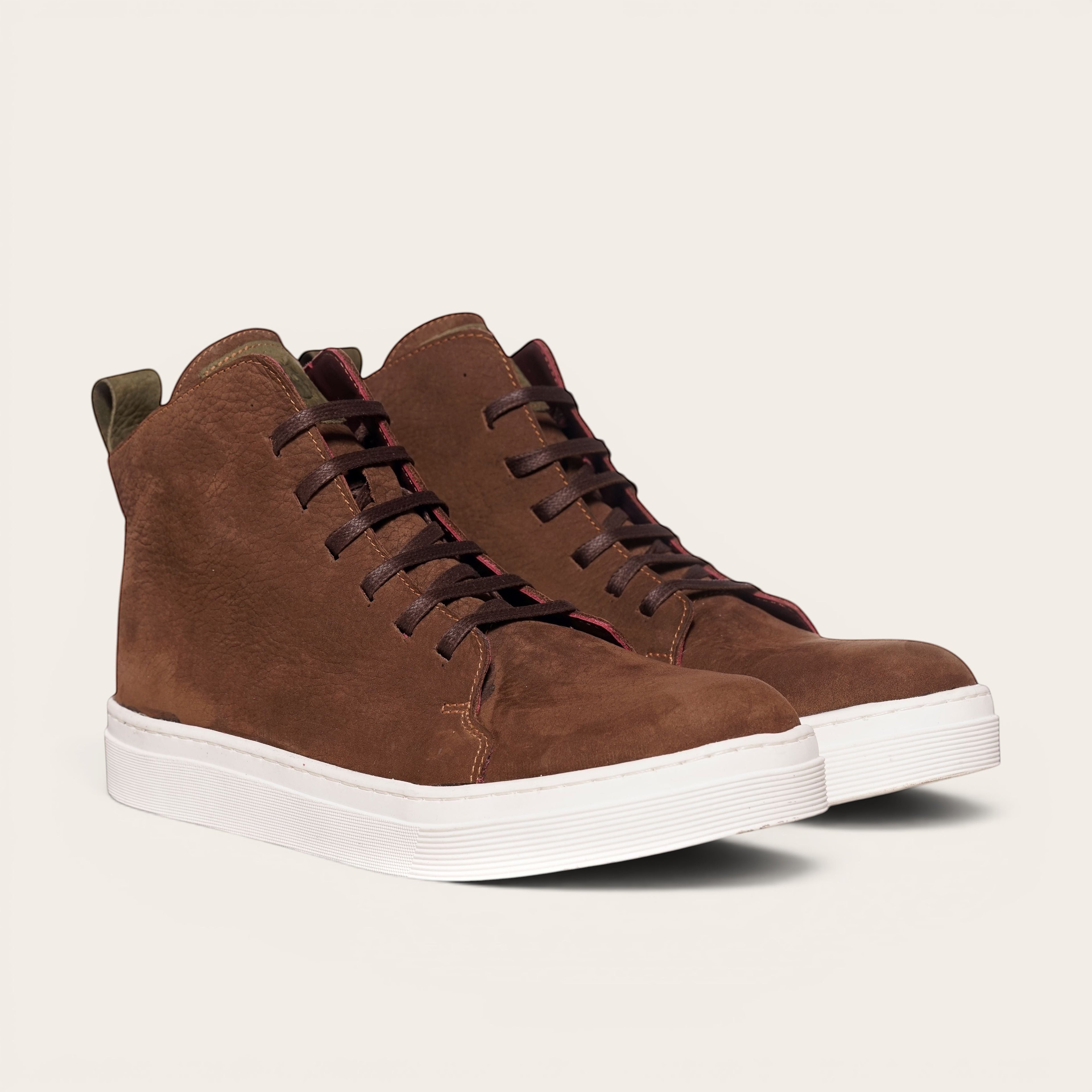 Zapatilla alta chocolate de cuero noburo con cordones de algodón encerado y planta blanca de caucho. OLKI.