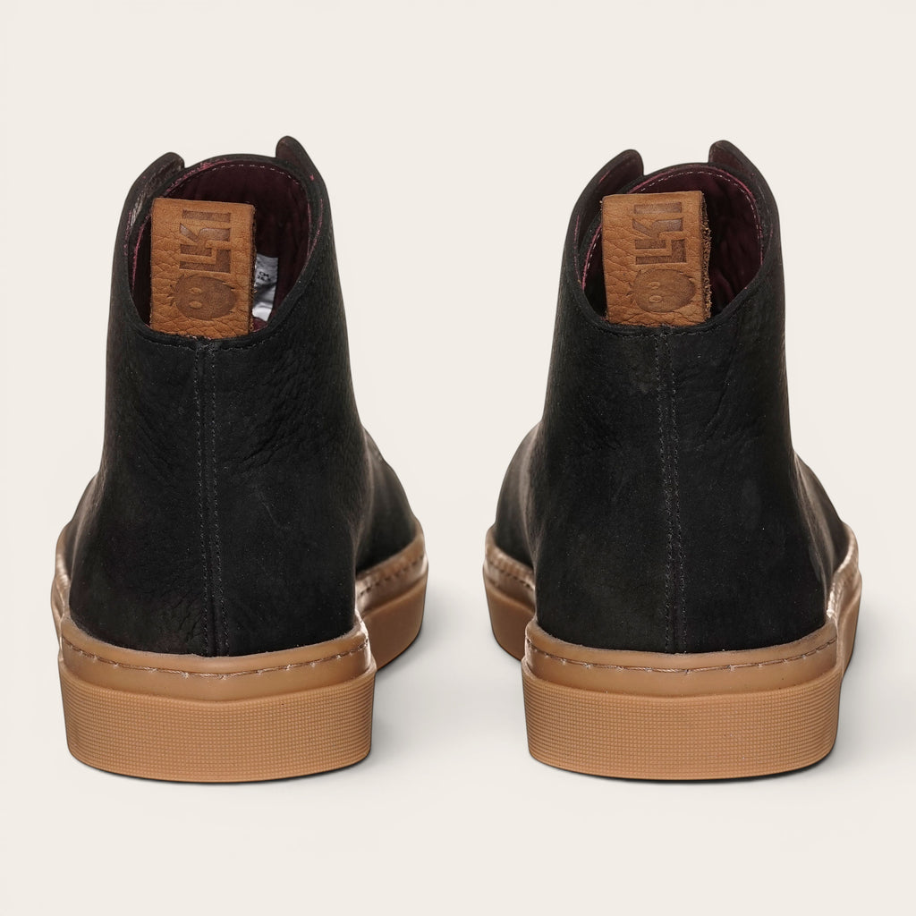 Zapatilla OLKI Manquehue negra de cuero nobuk con cordones de algodón y planta de caucho antideslizante.