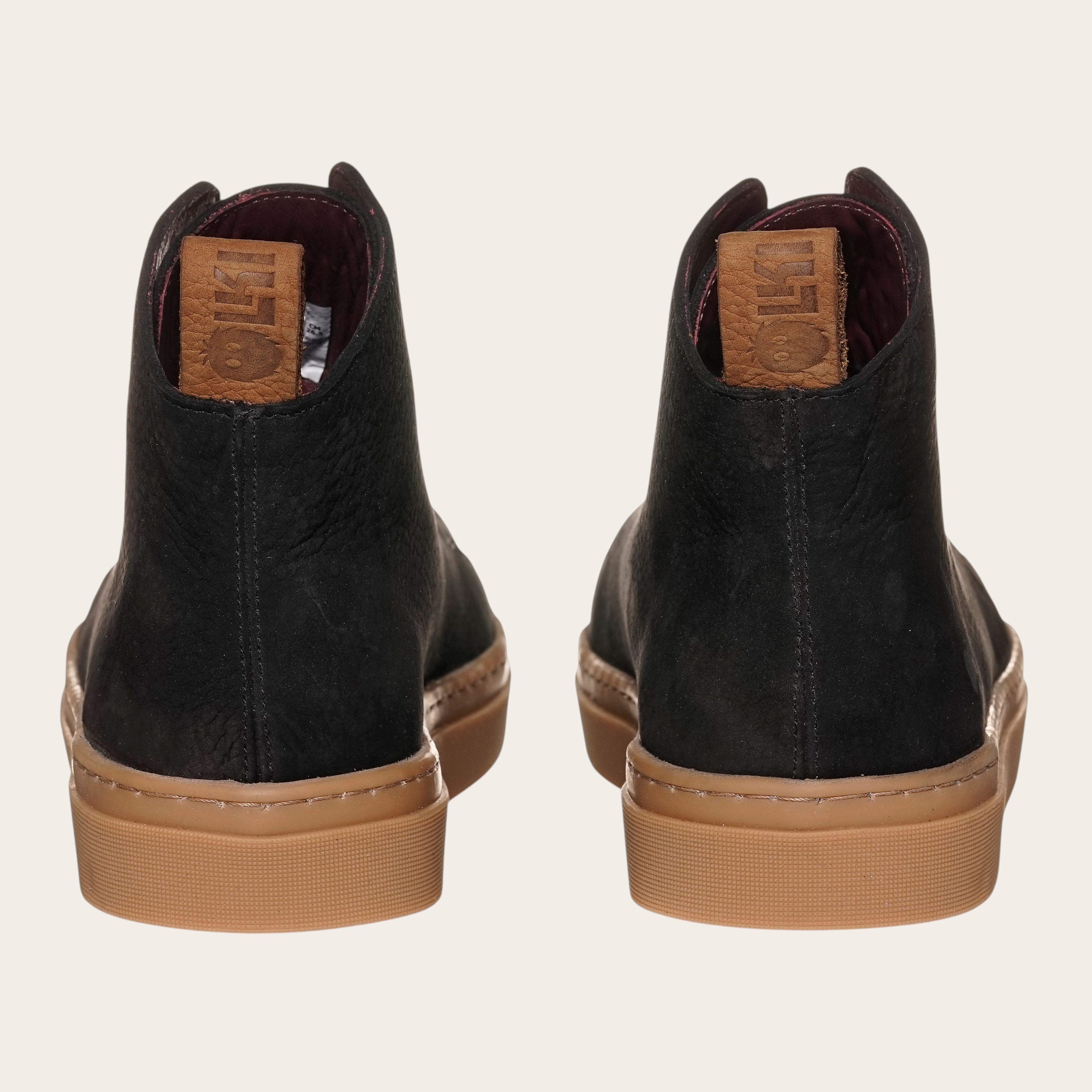 Zapatilla OLKI Manquehue negra de cuero nobuk con cordones de algodón y planta de caucho antideslizante.