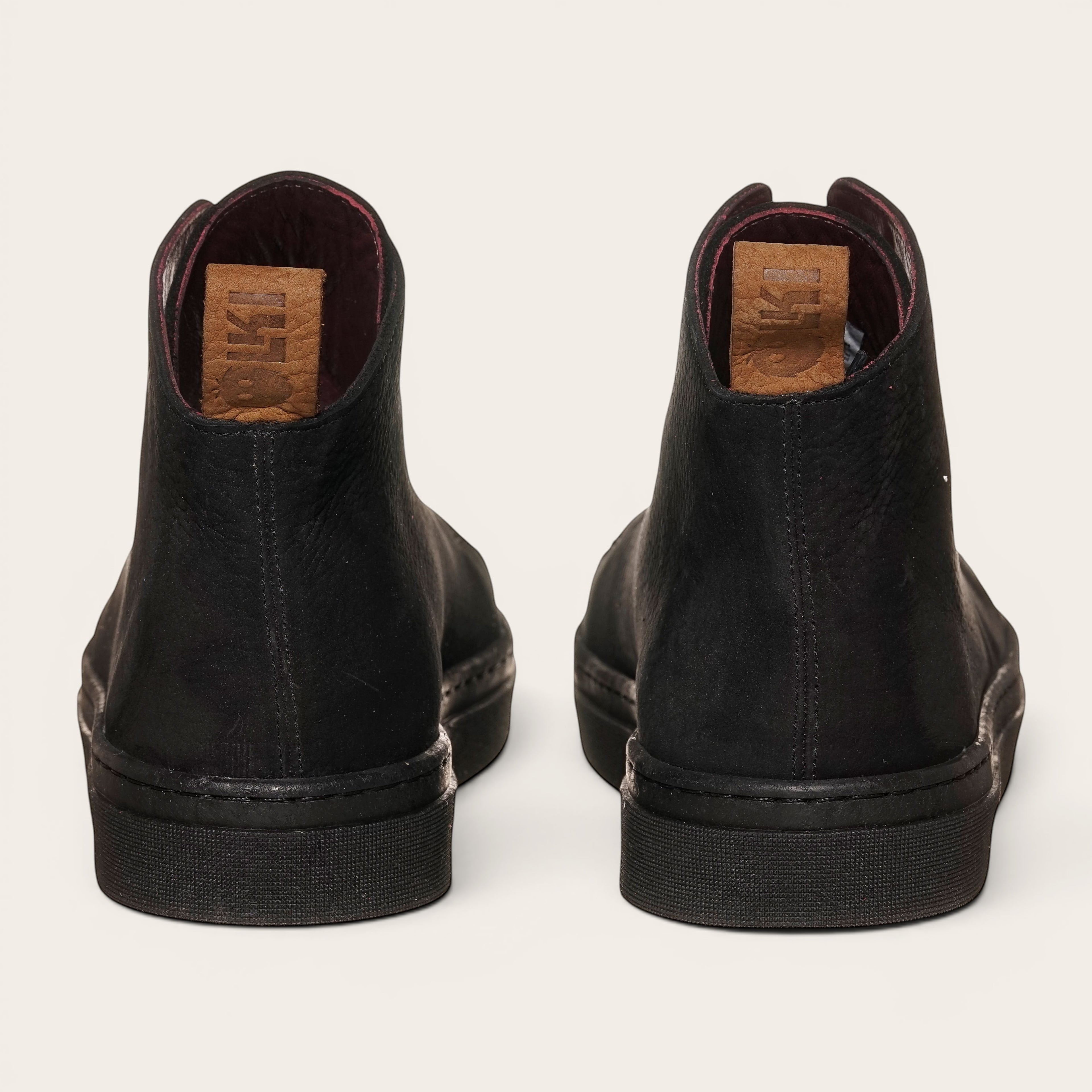 Zapatilla OLKI Manquehue negra de cuero nobuk con cordones, planta de caucho y plantilla antibacteriana. Diseño urbano.