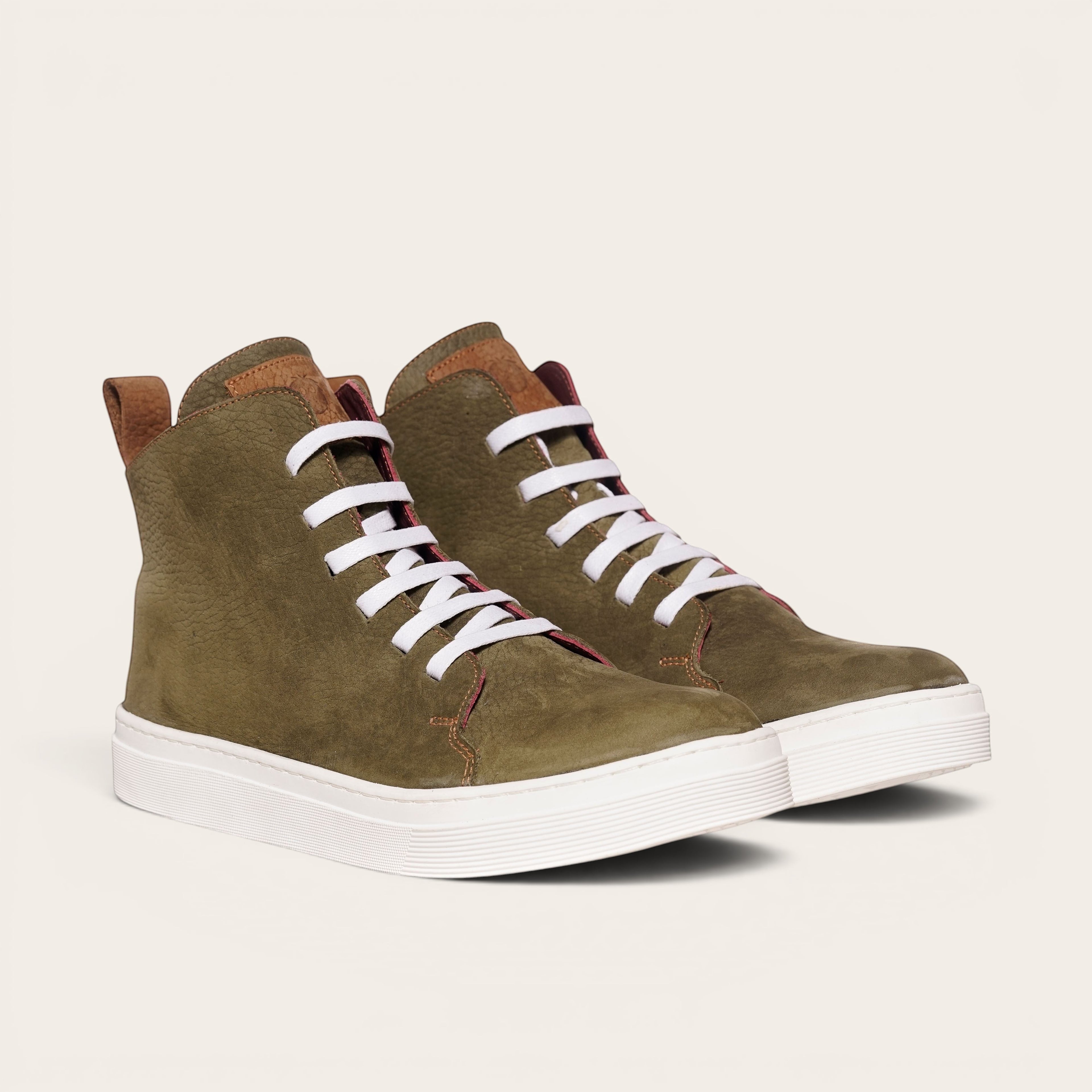 Zapatillas altas OLKI Manquehue de nobuk verde musgo con cordones blancos y planta blanca gruesa.