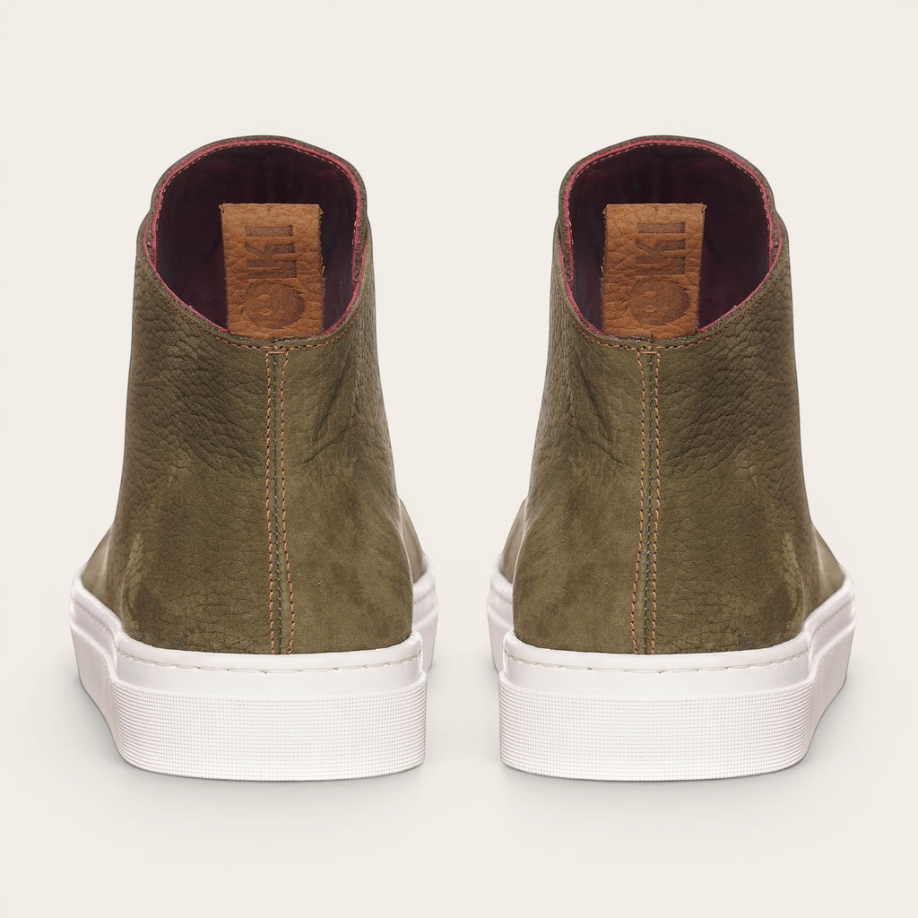 Zapatilla OLKI Manquehue verde musgo de cuero con cordones blancos y planta blanca gruesa. Diseño urbano.