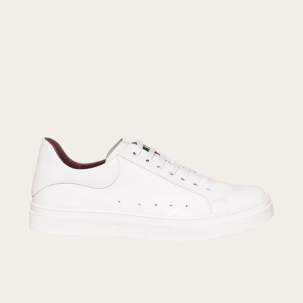 Zapatilla OLKI Nevado blanca de cuero con detalles interiores burdeos y cordones blancos. Diseño artesanal.