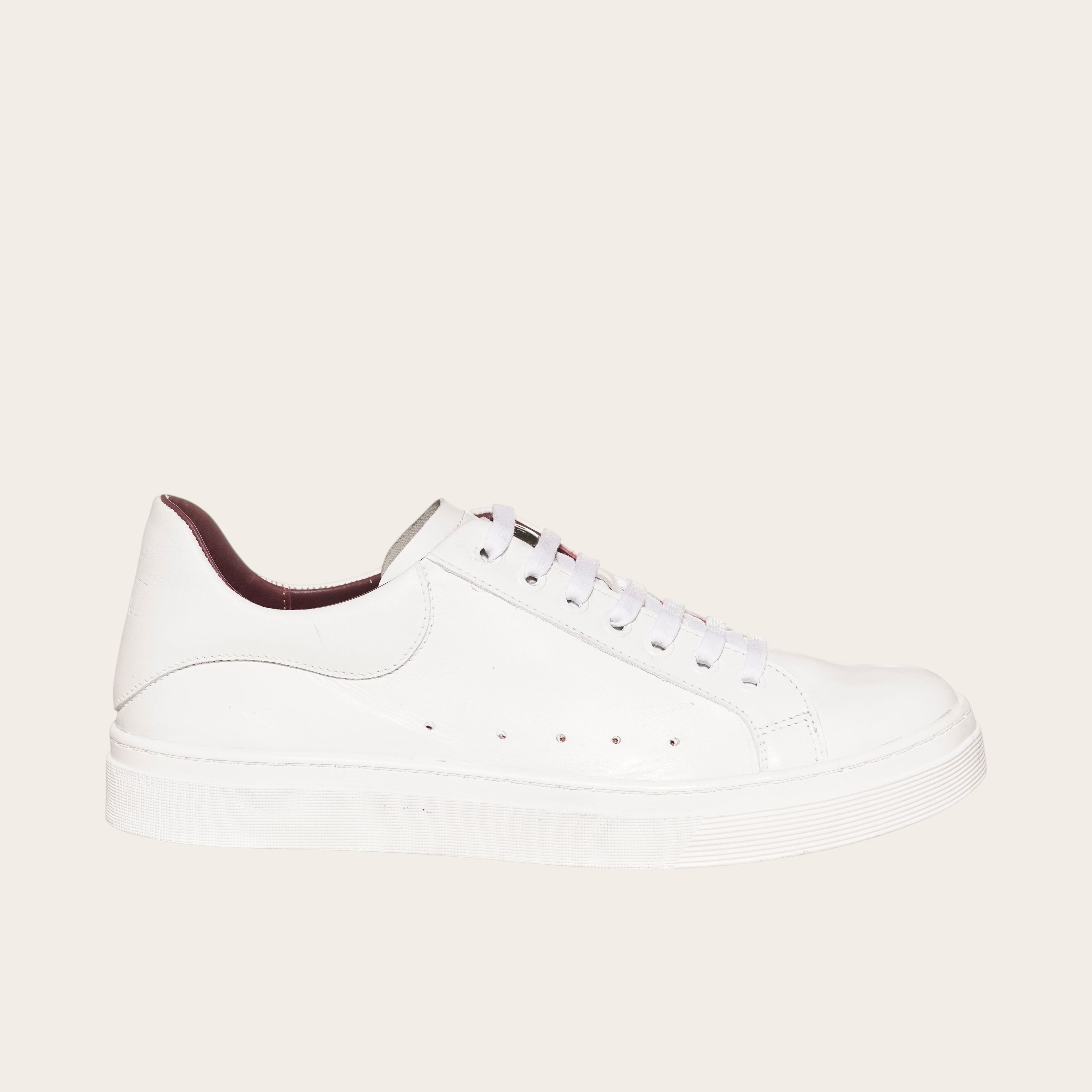 Zapatilla OLKI Nevado blanca de cuero con detalles interiores burdeos y cordones blancos. Diseño artesanal.