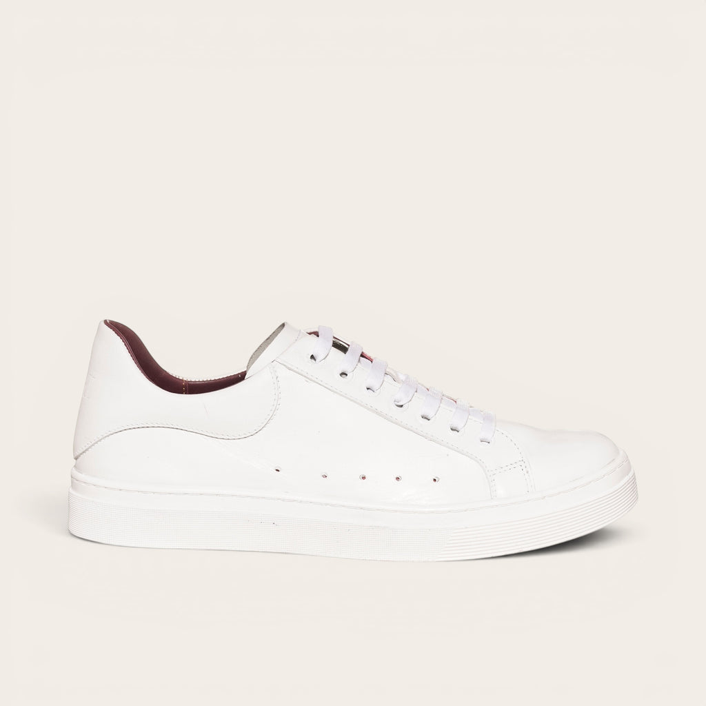 Zapatilla OLKI Nevado blanca de cuero con detalles interiores burdeos y cordones blancos. Diseño artesanal.