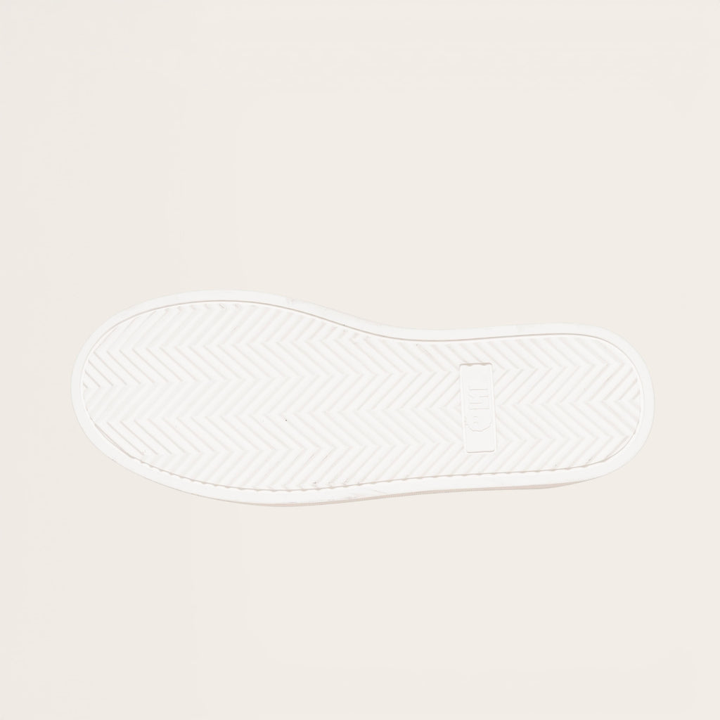 OLKI Zapatilla Nevado blanca planta de caucho antideslizante con patrón de espiga y logo. Diseño urbano.