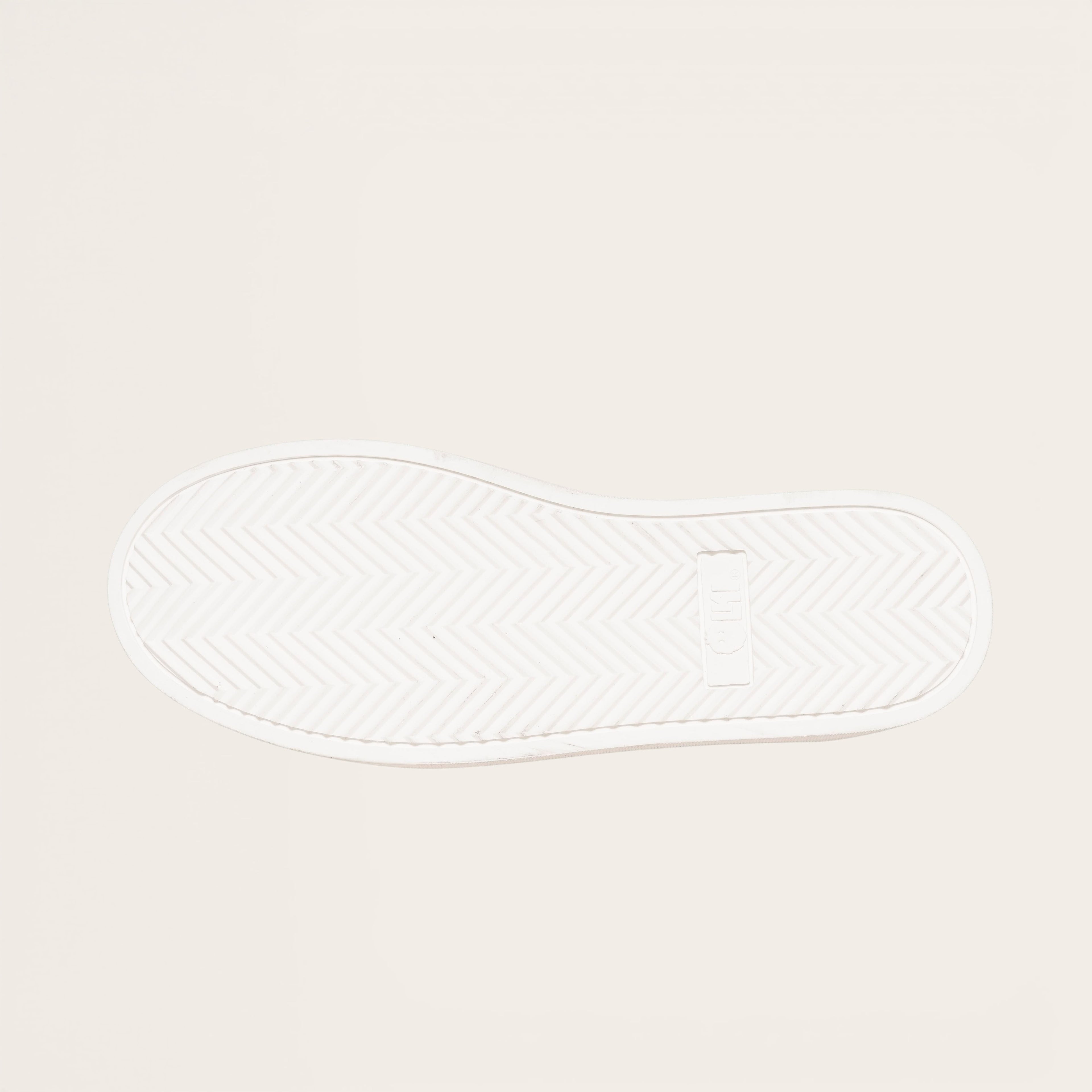 OLKI Zapatilla Nevado blanca planta de caucho antideslizante con patrón de espiga y logo. Diseño urbano.
