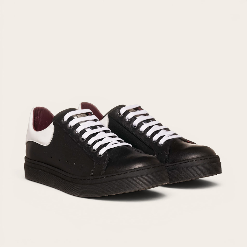 Zapatillas OLKI Nevado negras de cuero con talonera blanca y cordones blancos. Planta de caucho.planta