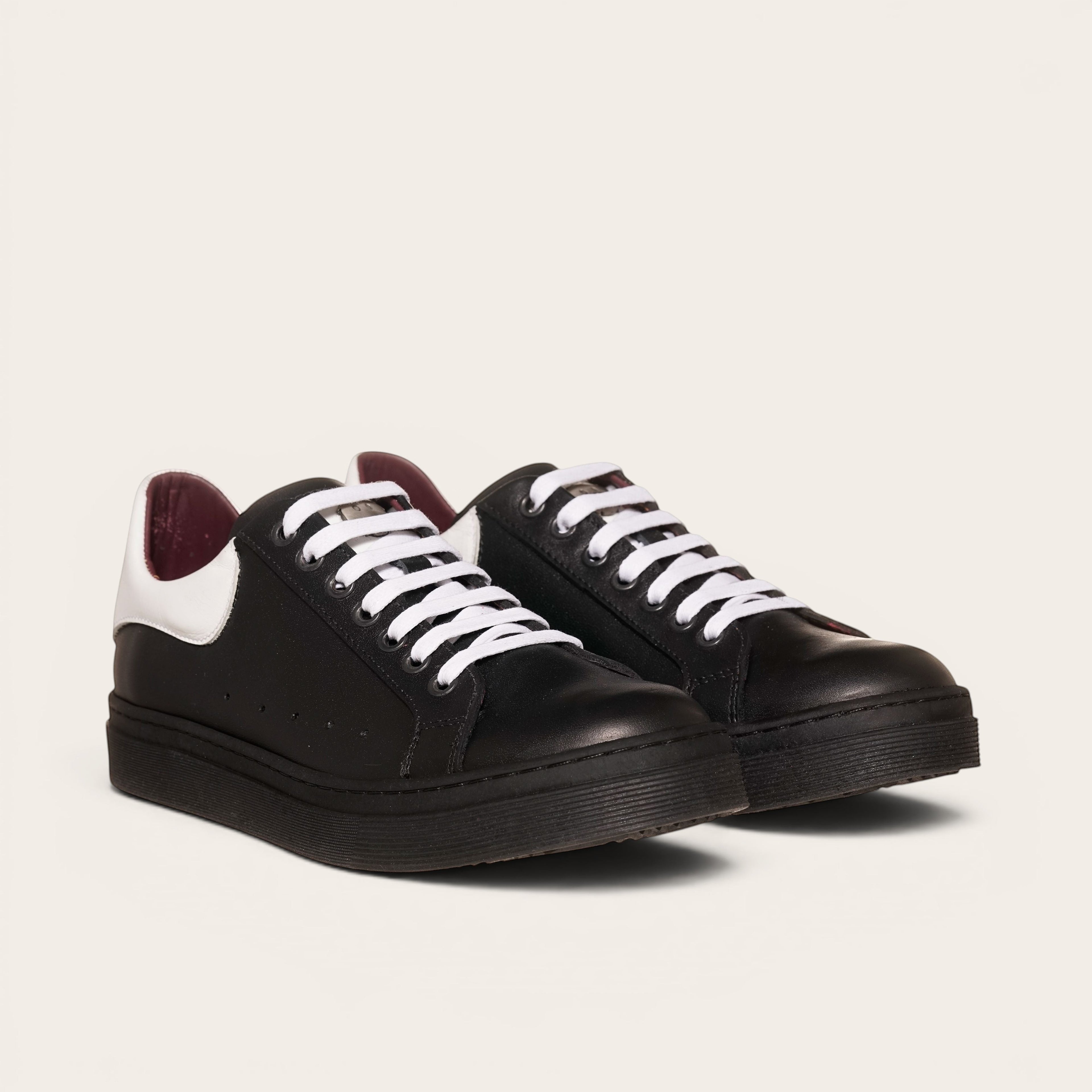 Zapatillas OLKI Nevado negras de cuero con talonera blanca y cordones blancos. Planta de caucho.planta