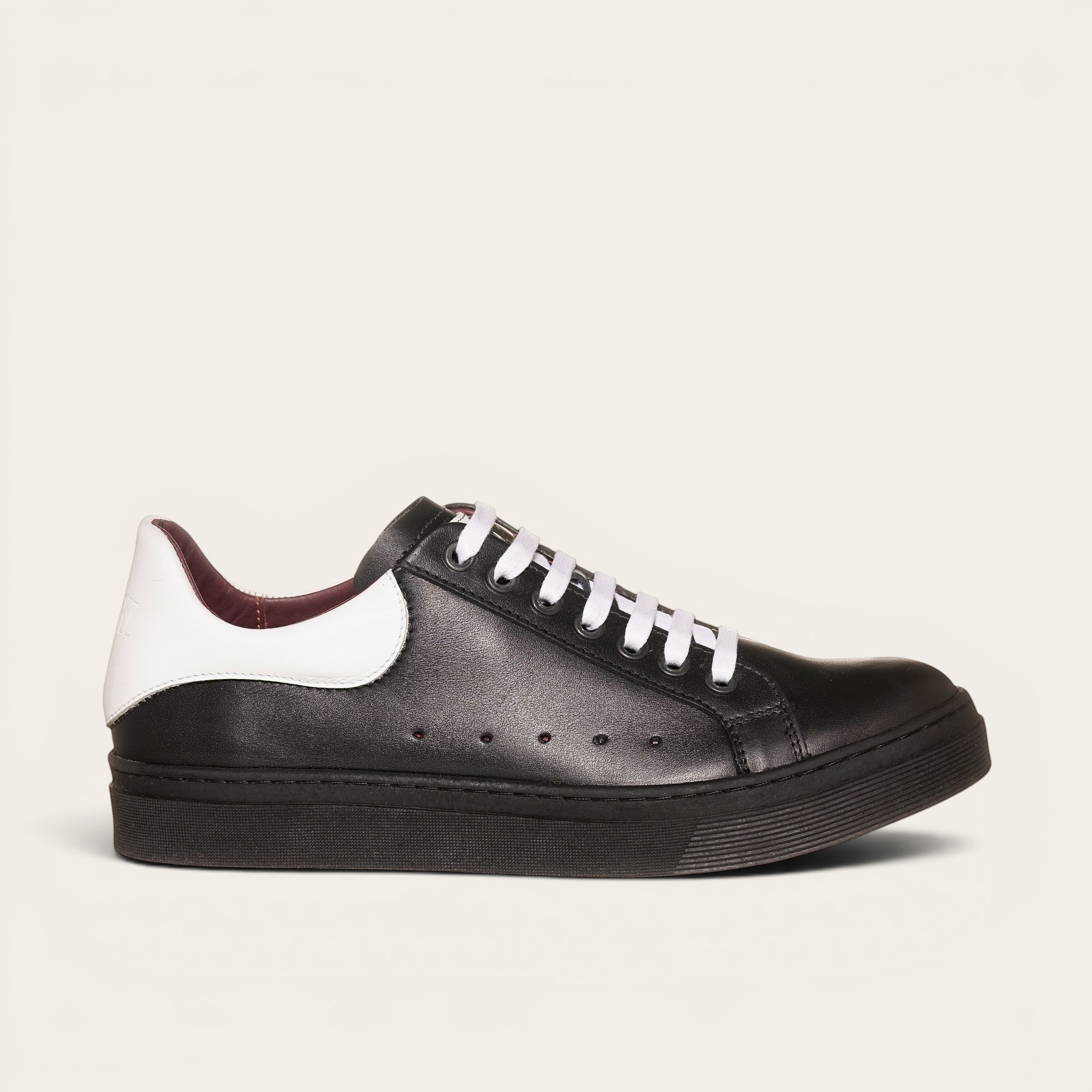 Zapatilla OLKI Nevado negra de cuero con talonera blanca y cordones blancos. Diseño artesanal chileno.
