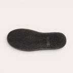 Zapatilla OLKI Nevado negra de cuero con talonera blanca y planta de caucho antideslizante.