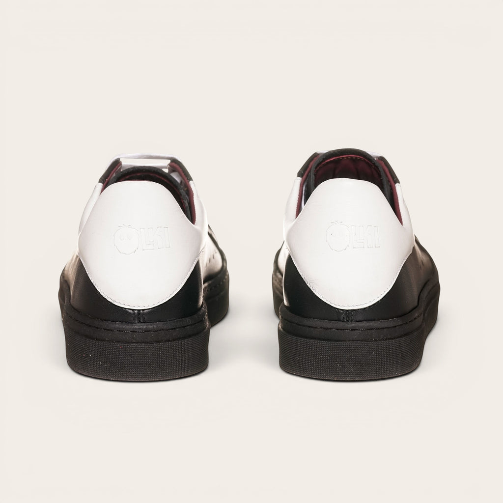 Zapatillas OLKI Nevado negras de cuero con talonera blanca y detalles en burdeos. Diseño artesanal chileno.