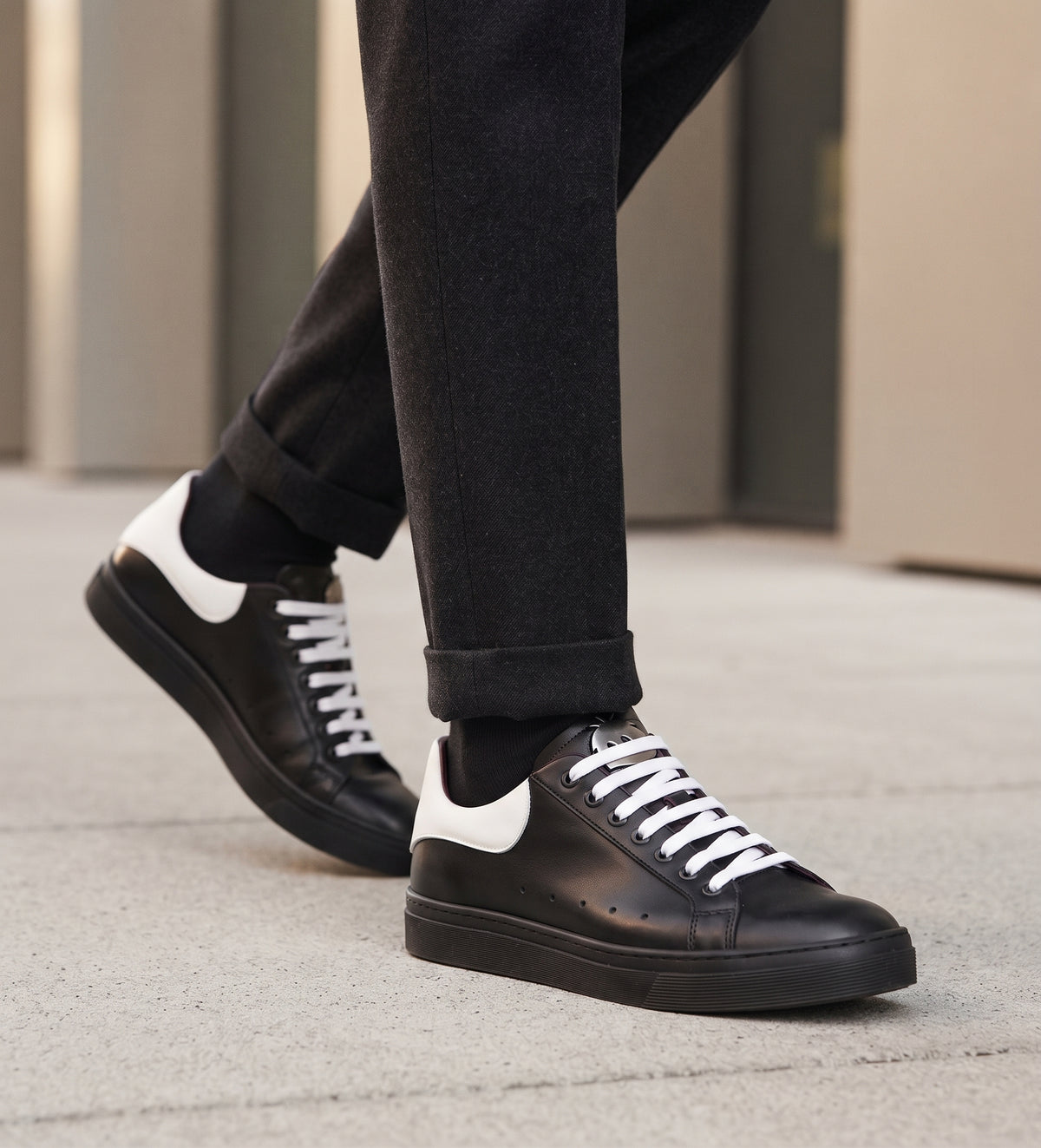 Zapatillas OLKI Nevado negras de cuero con talonera blanca y cordones blancos. Planta de caucho.