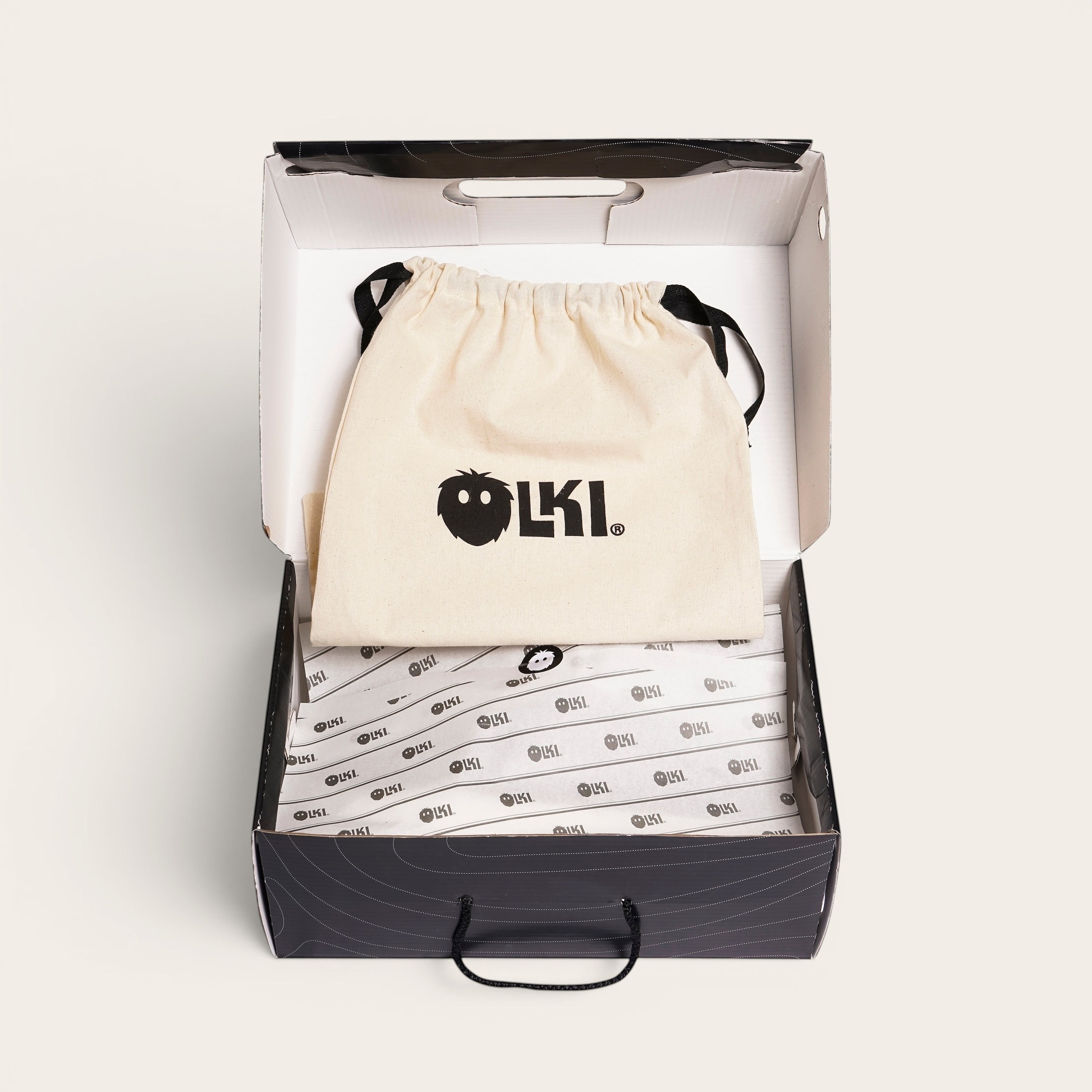 OLKI Zapatilla Nevado Negra, zapatilla de cuero negro con talonera negra, forro de cuero guinda y planta de caucho antideslizante. Presentada en su caja con bolsa protectora.