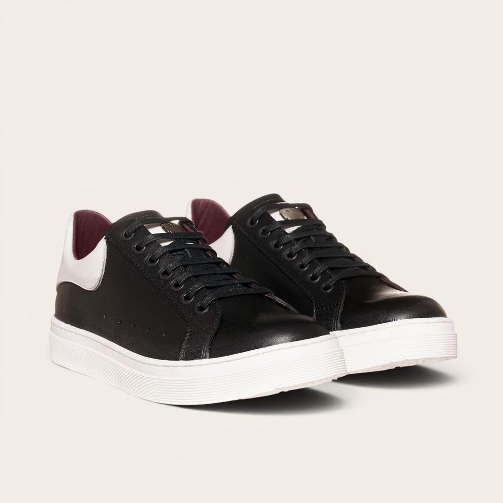 Zapatilla OLKI Nevado negra de cuero con talonera blanca y forro guinda. Cordones de algodón.