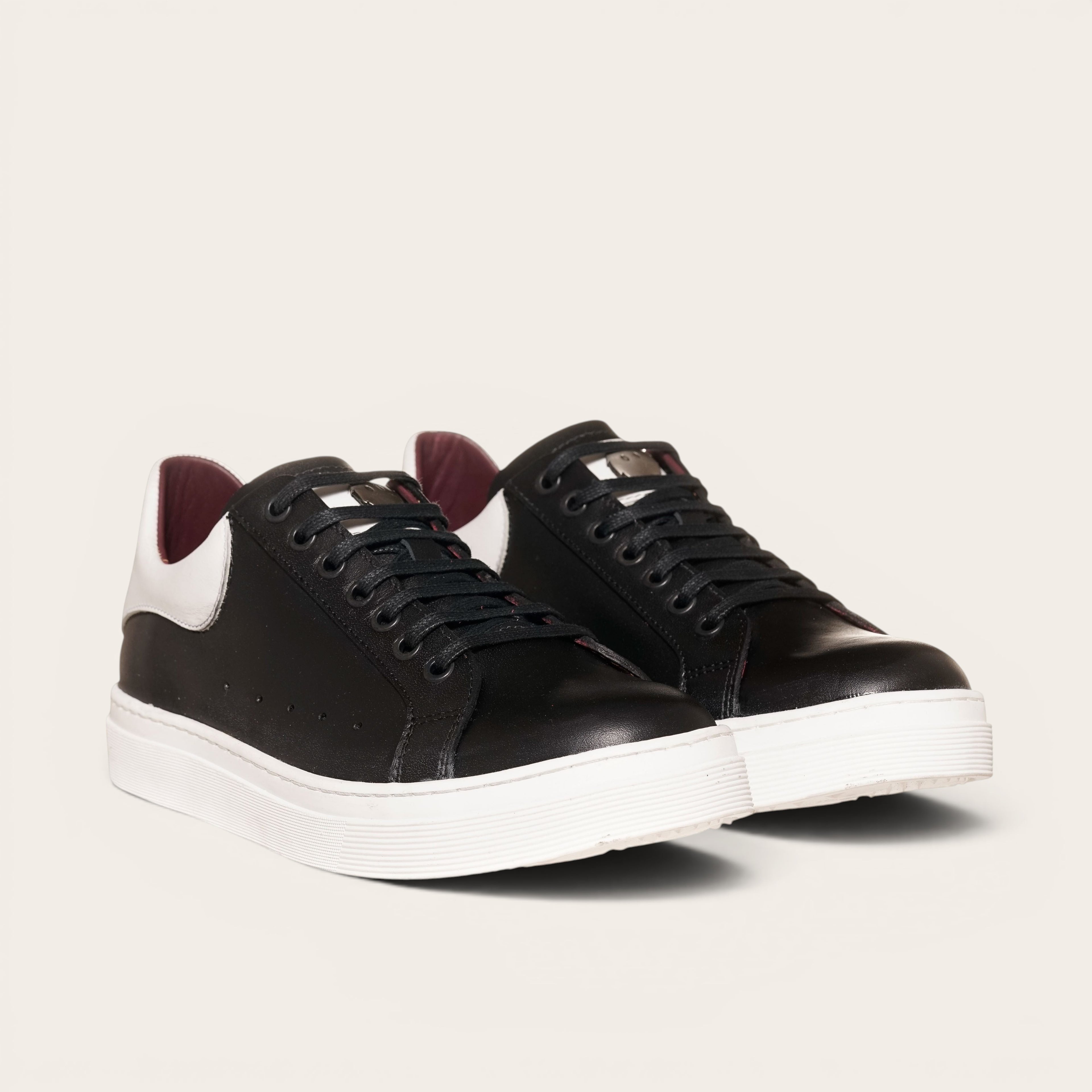 Zapatilla OLKI Nevado negra de cuero con talonera blanca y forro guinda. Cordones de algodón.