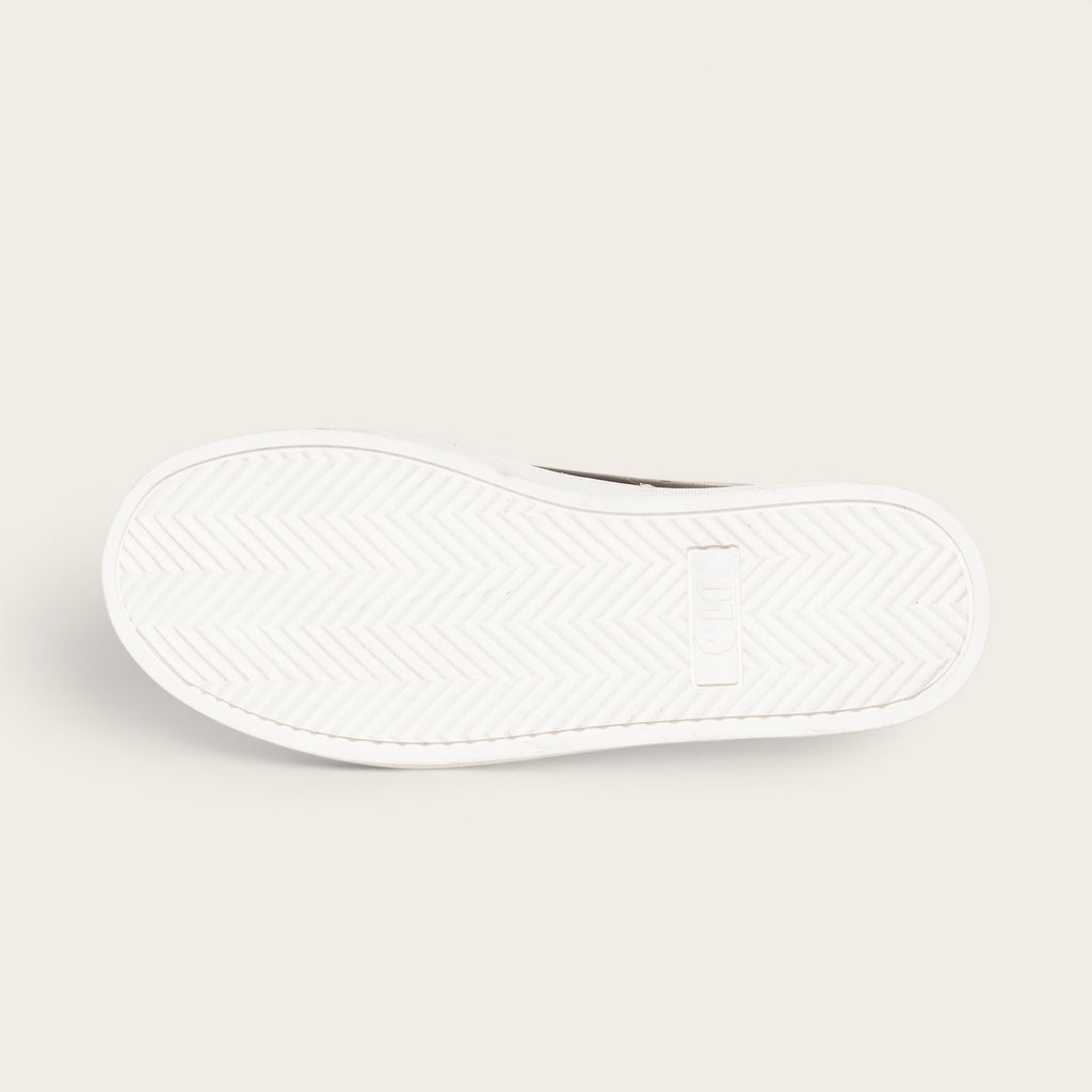 Zapatilla OLKI Nevado negra de cuero con talonera blanca y planta de caucho antideslizante.