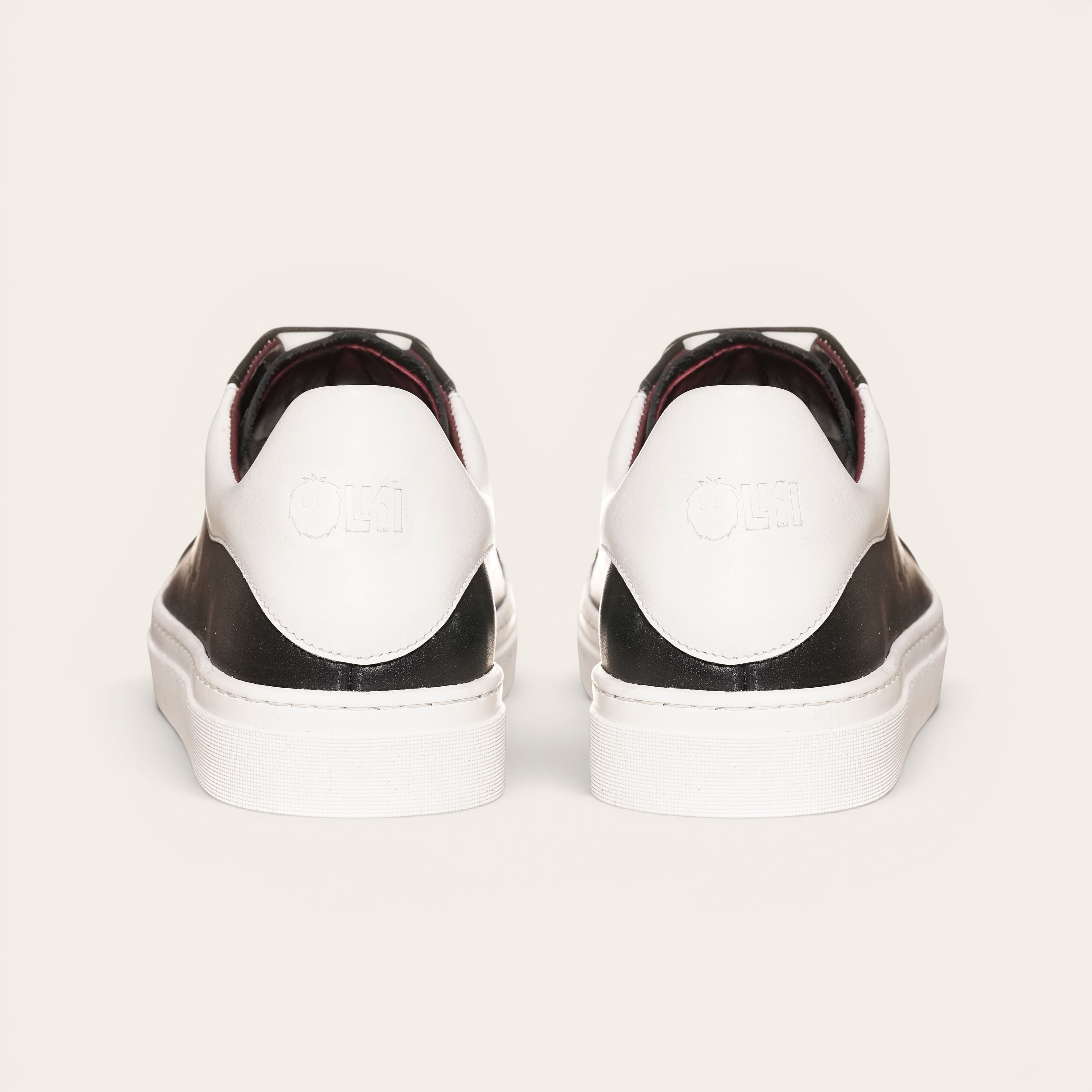 Zapatilla OLKI Nevado negra de cuero con talonera blanca y planta de caucho. Diseño artesanal chileno.