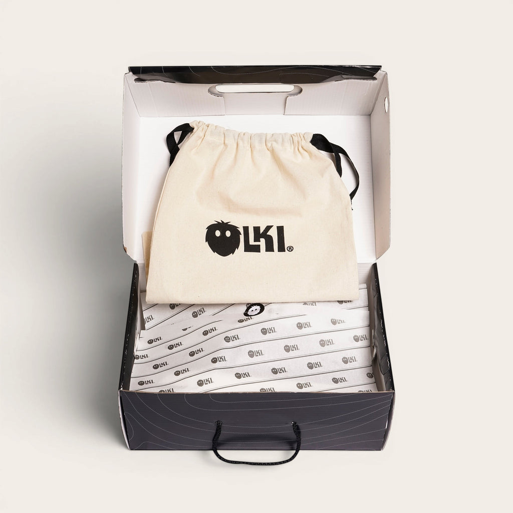 OLKI Zapatilla Tronador Tostado Planta Chocolate, zapatilla de cuero vacuno con forro de cuero natural y suela de caucho antideslizante, presentada en su caja con bolsa protectora.