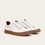 Zapatilla blanca de cuero de vacuno de OLKI con planta de caucho marrón y forro guinda. Diseño clásico con cordones.