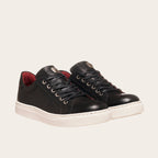 Zapatilla OLKI Tronador negra de cuero con cordones, forro guinda y planta blanca antideslizante. Diseño artesanal chileno.