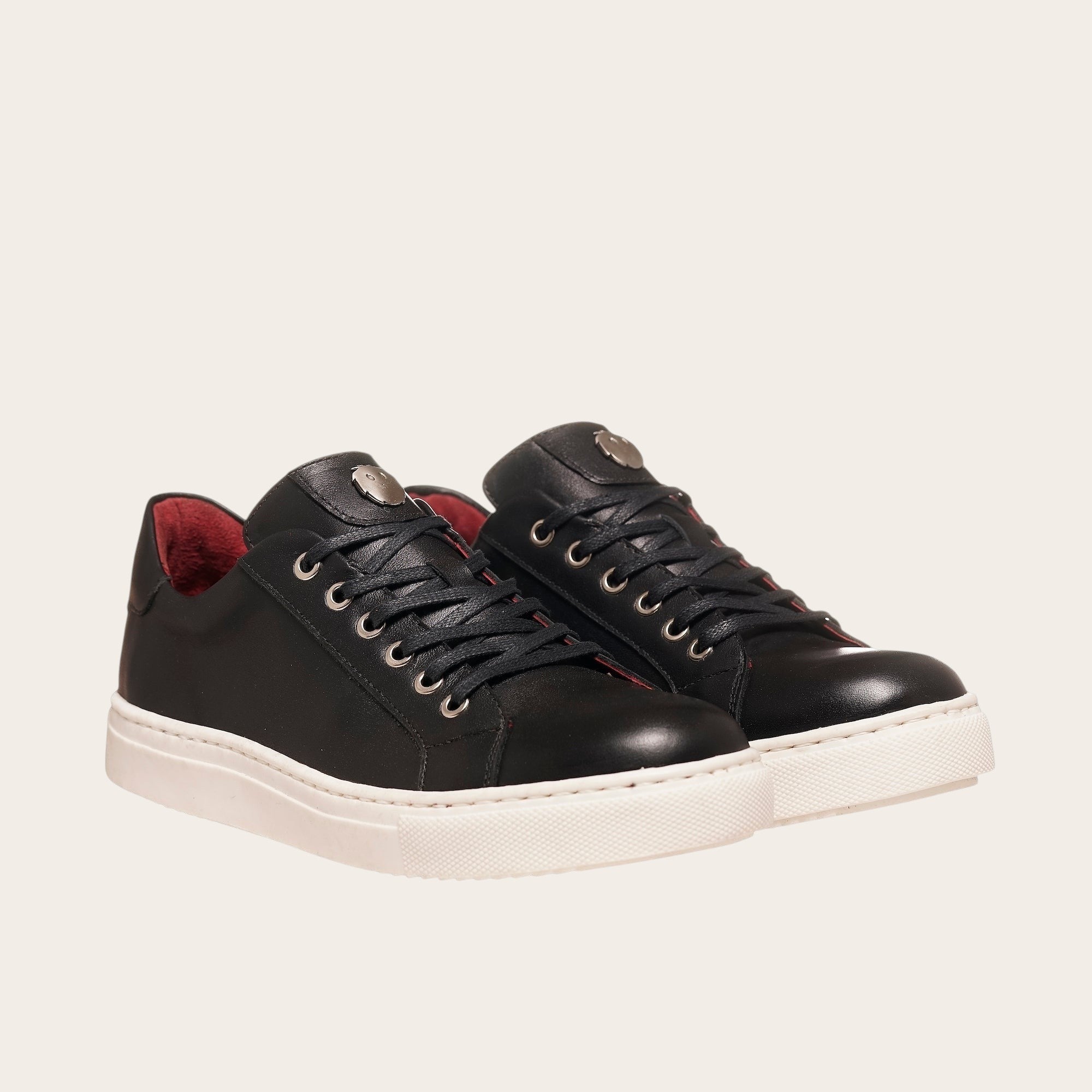 Zapatilla OLKI Tronador negra de cuero con cordones, forro guinda y planta blanca antideslizante. Diseño artesanal chileno.