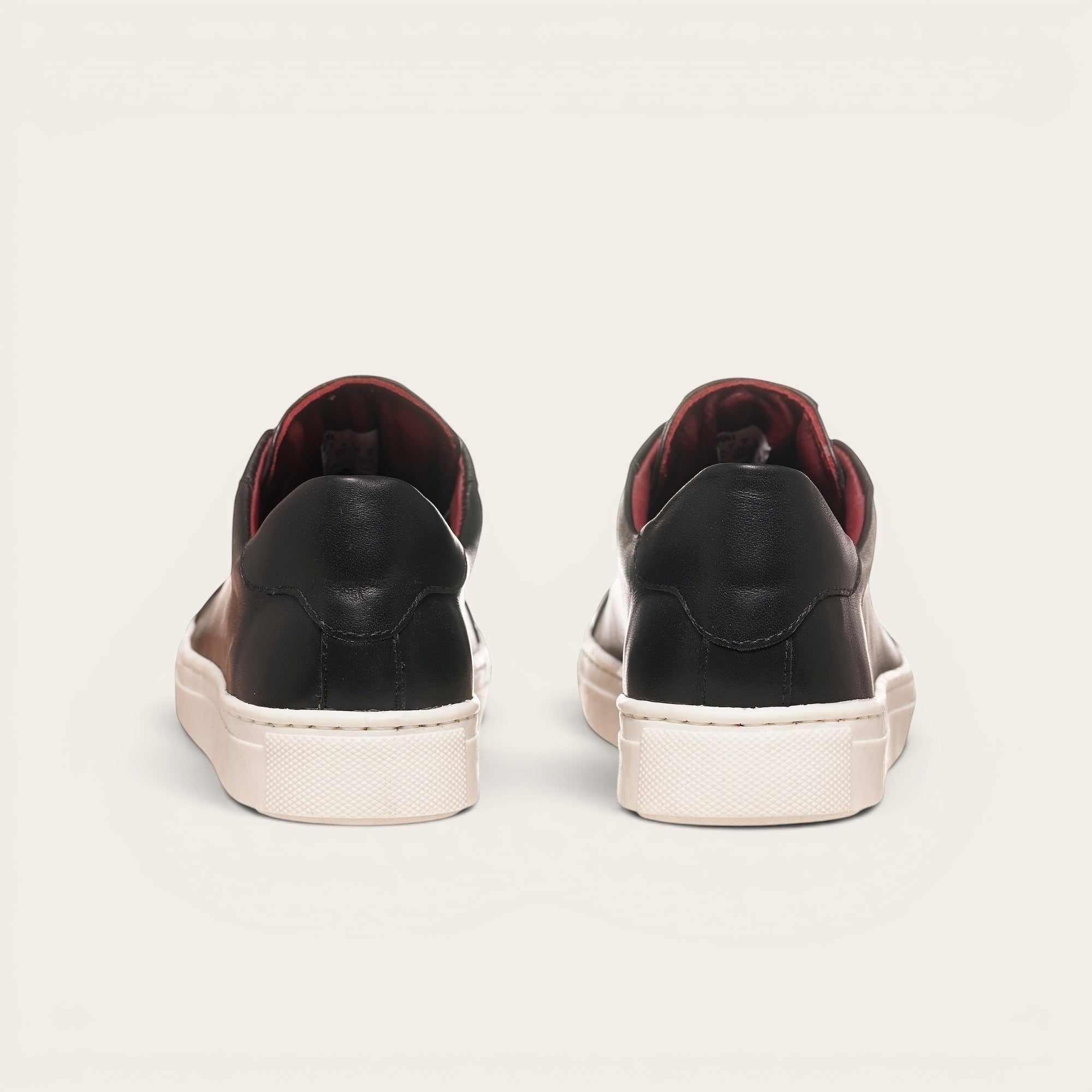 Zapatillas OLKI Tronador negras de cuero con planta blanca y forro guinda. Diseño artesanal chileno.