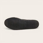 Zapatilla OLKI Tronador negra de cuero con suela de caucho antideslizante y cordones de algodón encerado.