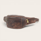 Banano OLKI Torres del Paine de cuero marrón chocolate con dos compartimentos y cremalleras doradas.