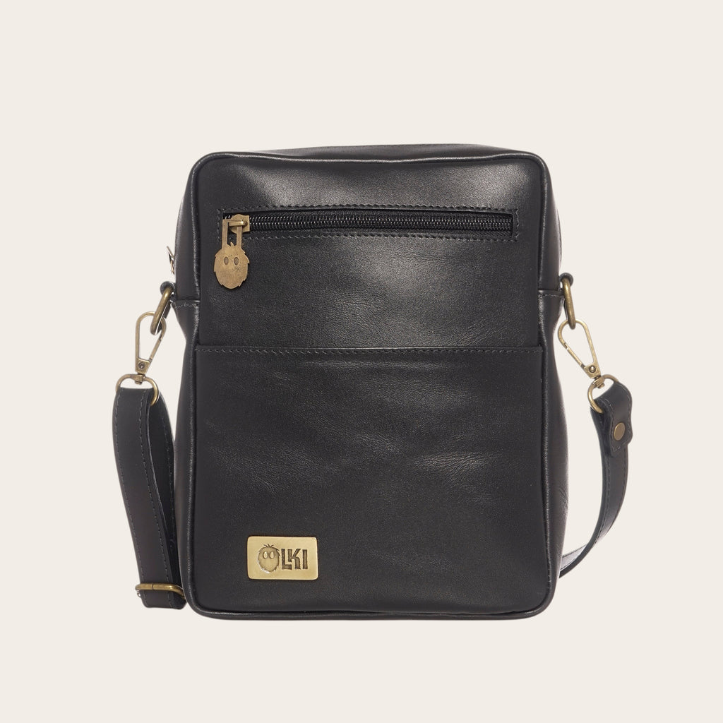 Bandolera negra de cuero natural OLKI Cautin con bolsillo exterior con cremallera y logo metálico.