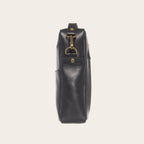 Bandolera negra de cuero natural OLKI Cautin con bolsillo exterior y herrajes dorados envejecidos.