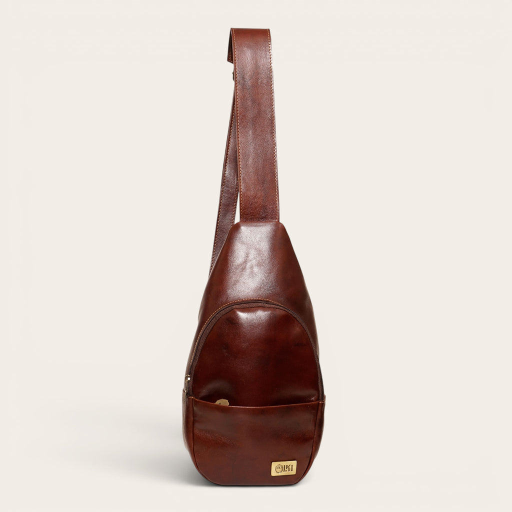 Bandolera Cunco Castaño de cuero natural de vacuno de OLKI, con correa ajustable y bolsillo exterior. Capacidad 3.5 litros.
