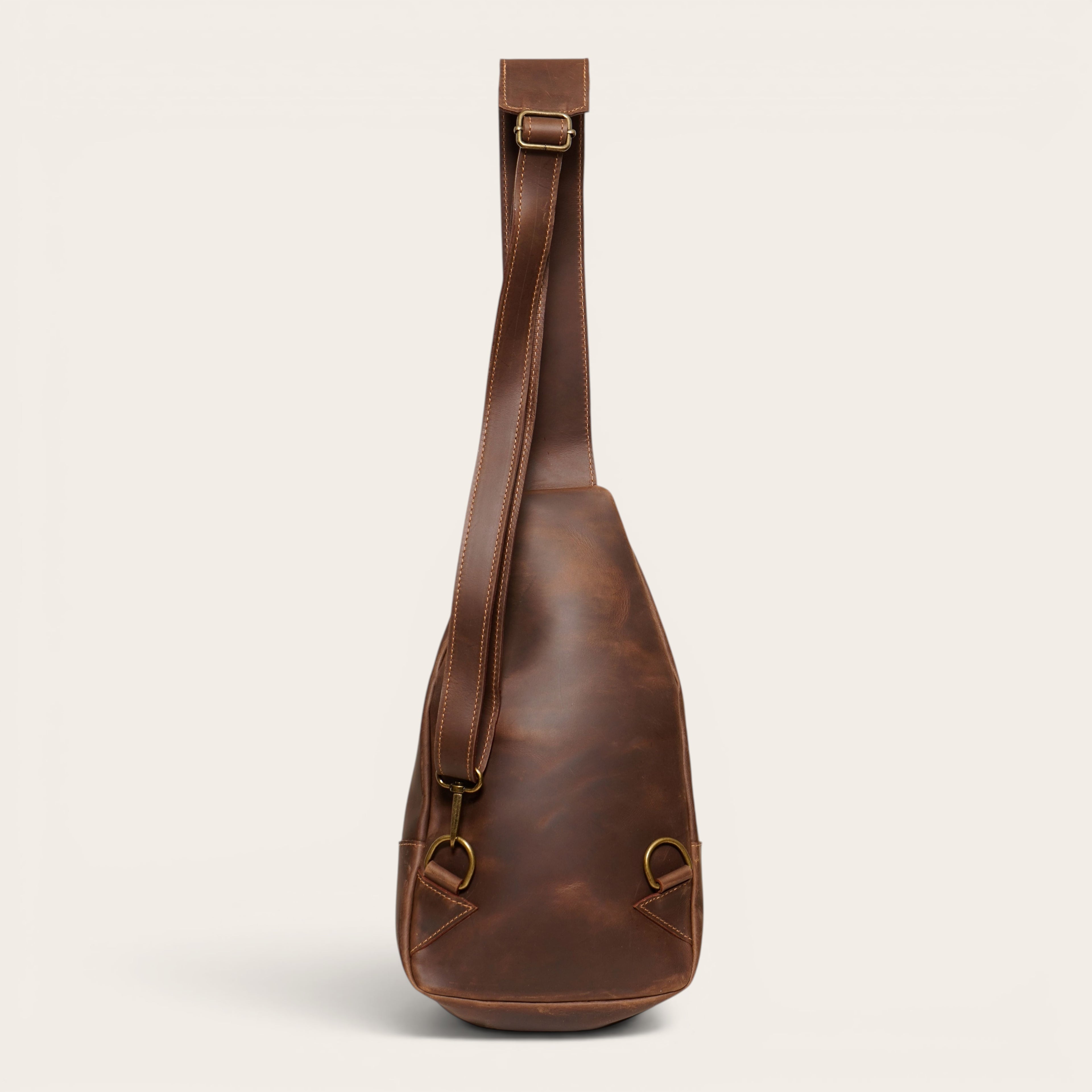 Bandolera Cunco de cuero natural marrón chocolate de OLKI con correa ajustable y herrajes metálicos.