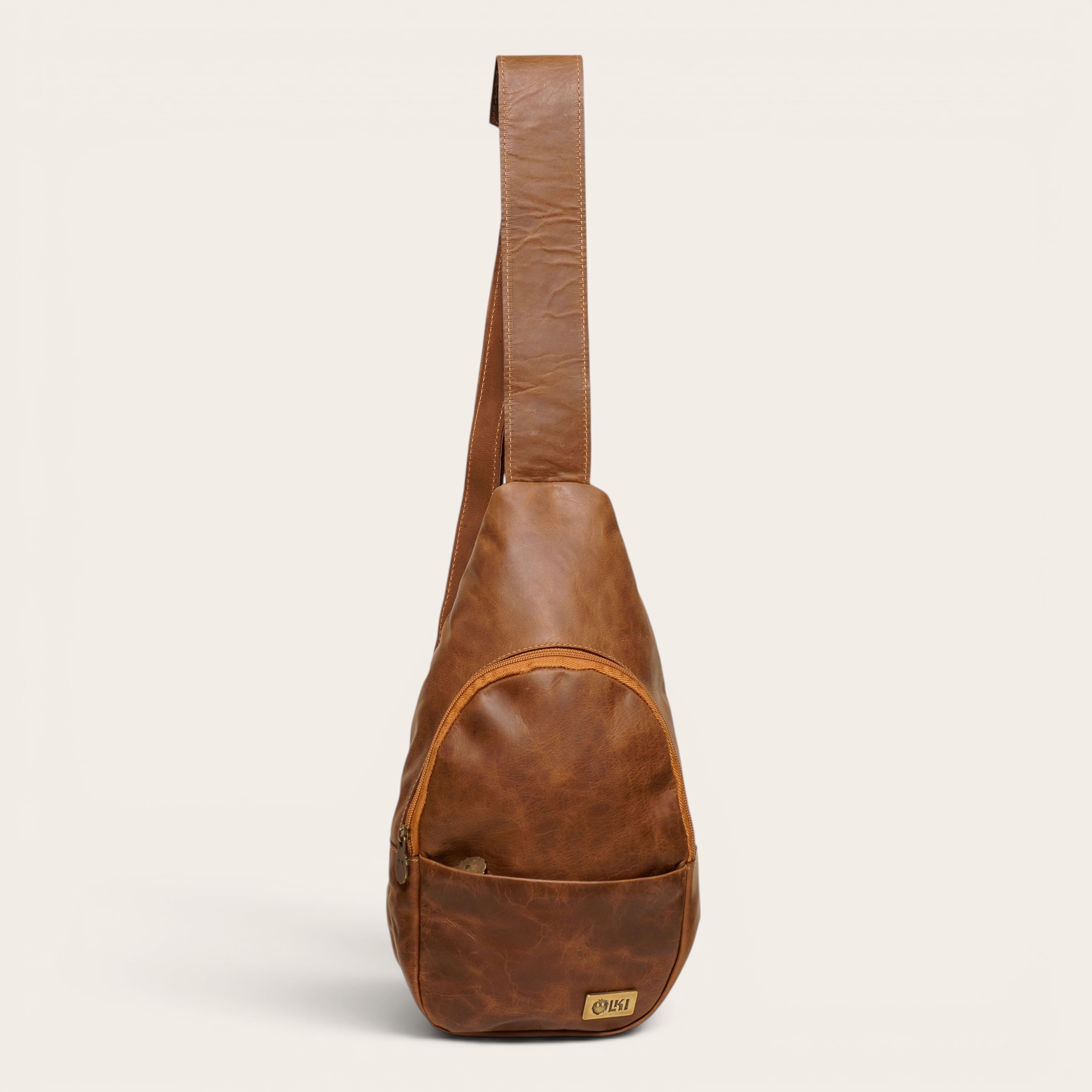 Bandolera Cunco Habano de cuero natural de vacuno de OLKI con bolsillo exterior y cremallera.